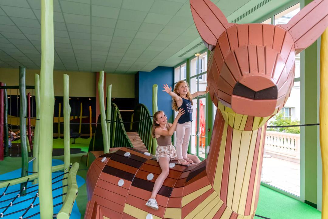 Kids climbing on wooden deer playground structure at Disney hotel