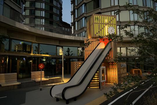 Post themed playground with big towers, illuminated at night