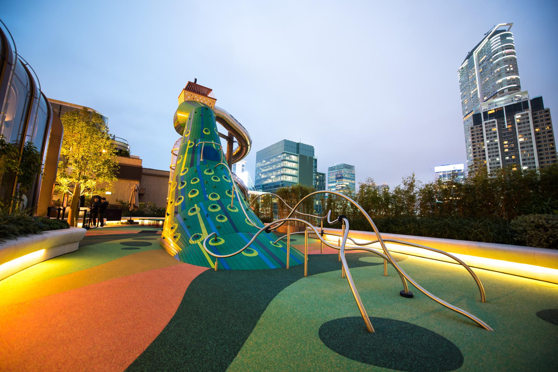 Peacock playground from behind, climbing grips and rails