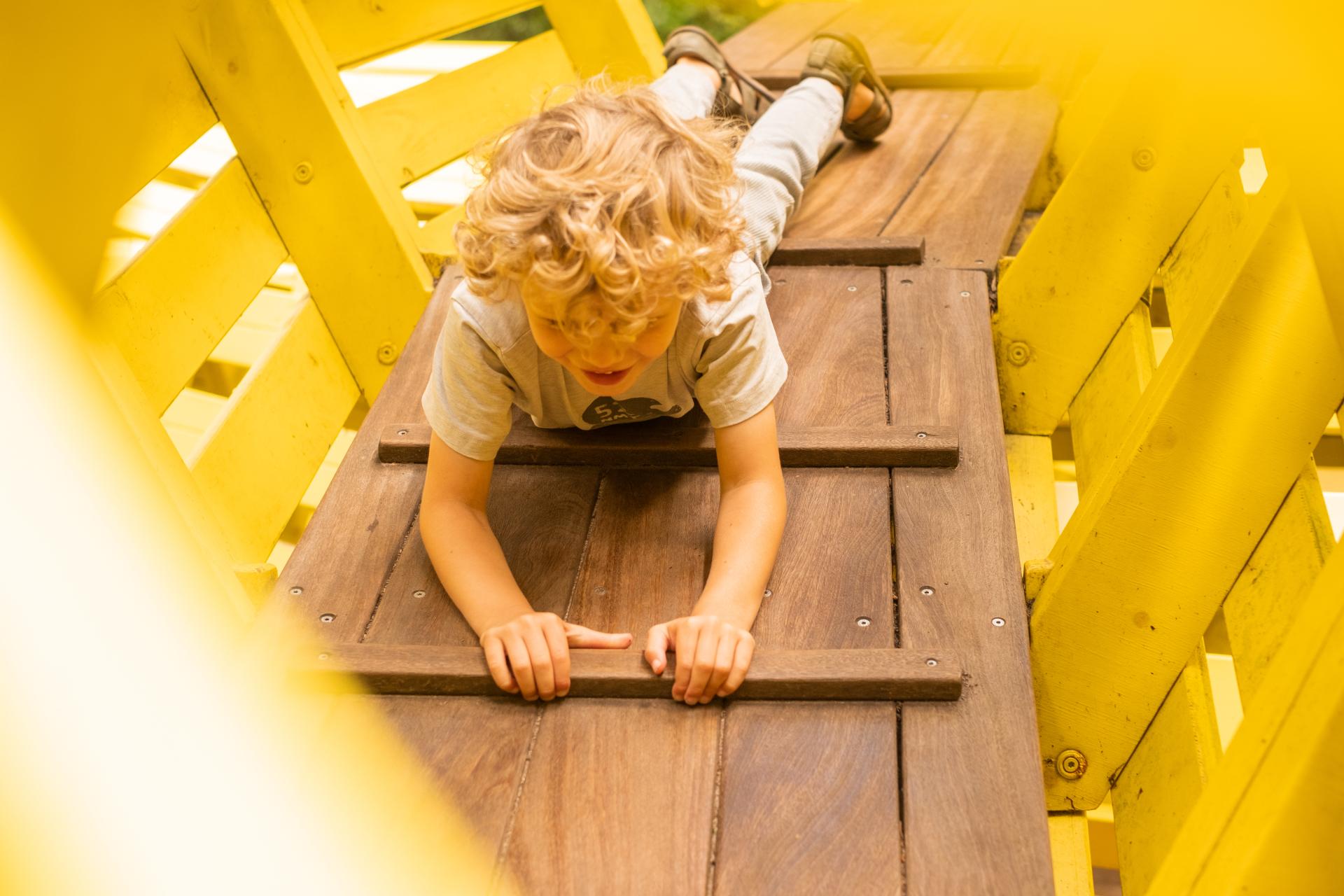 Boy playing and climbing inside snake playground