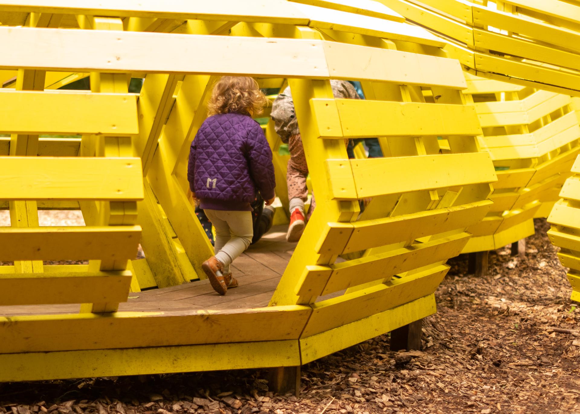 Girl playing inside Snake playground sculpture