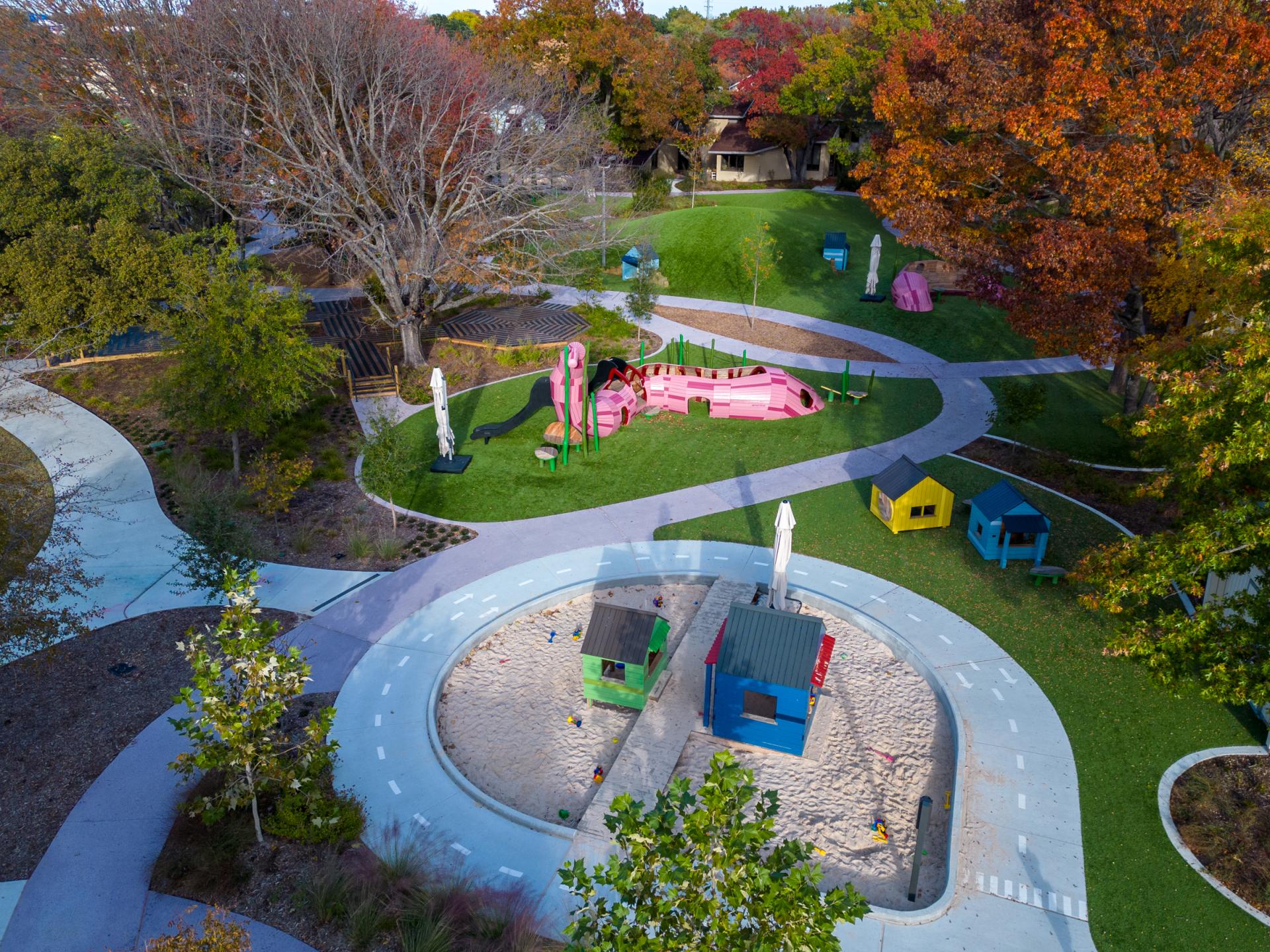 Aerial view of wooden earthworm structure and wooden playhouses at Lamplighter School playground