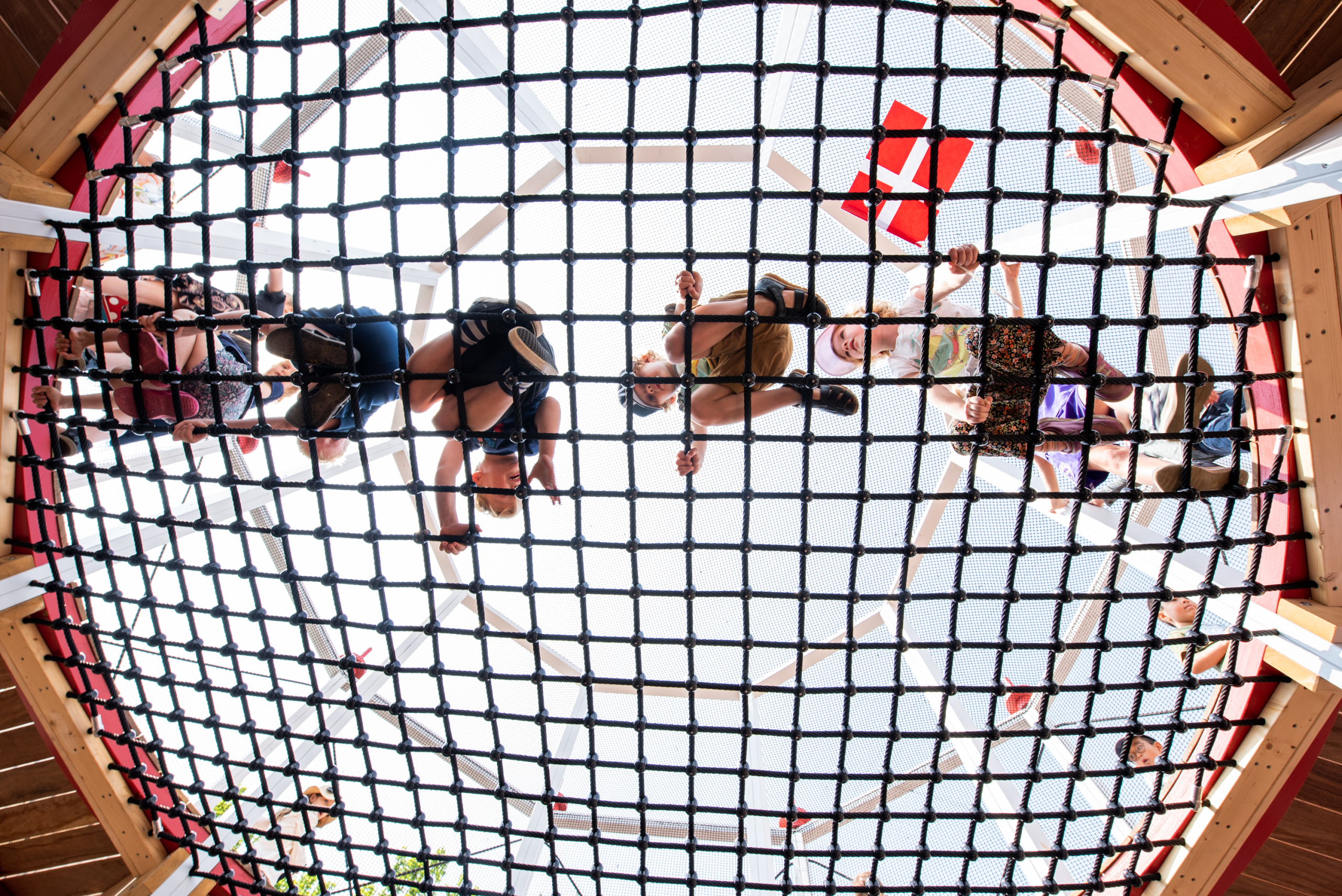 Kids climbing across rope net, MONSTRUM Playground