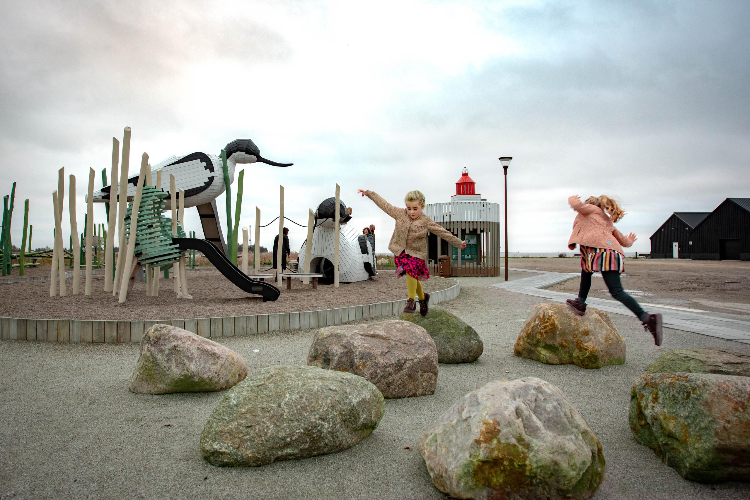 Kids climbing and playing on avocet bird playground sculpture