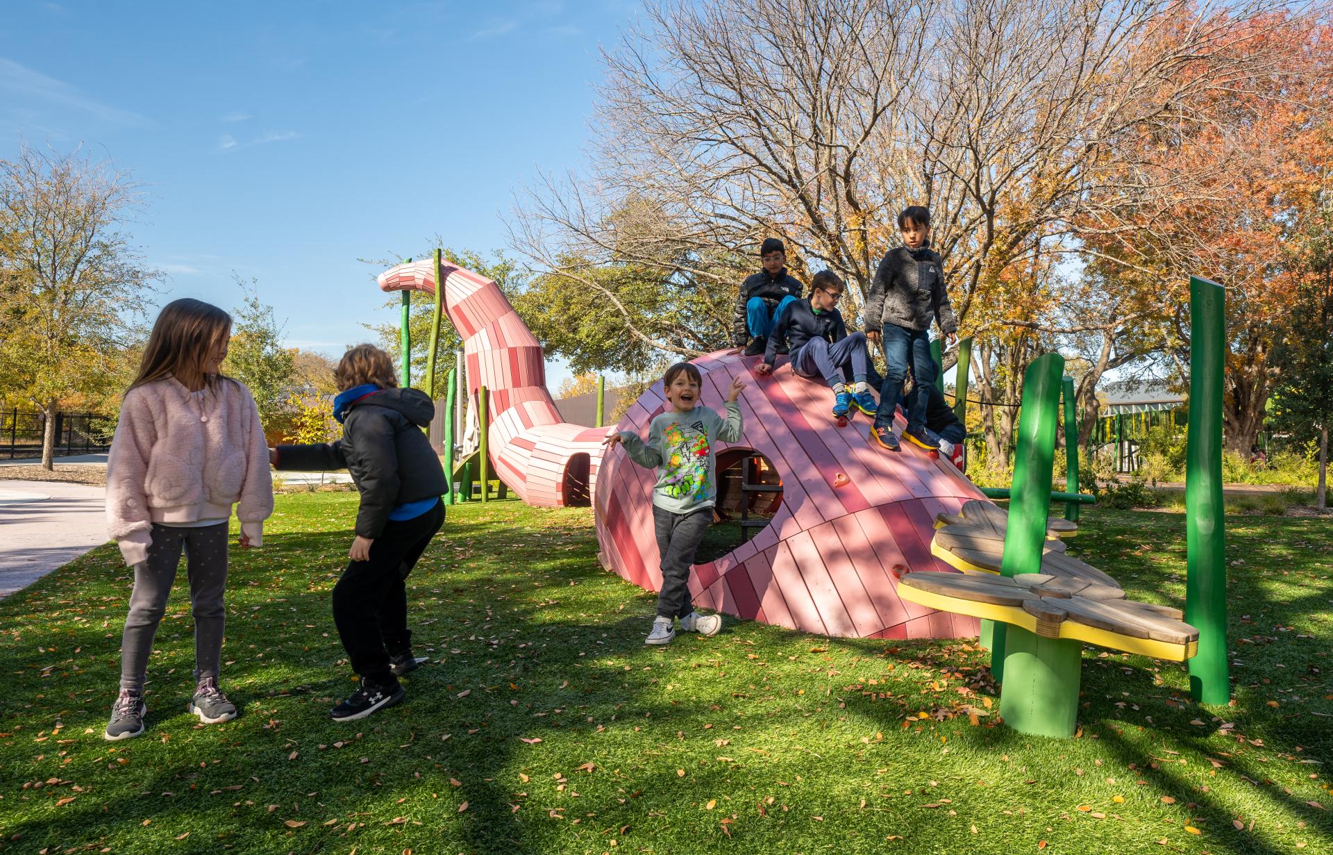 Kids playing at worm play structure in school playground