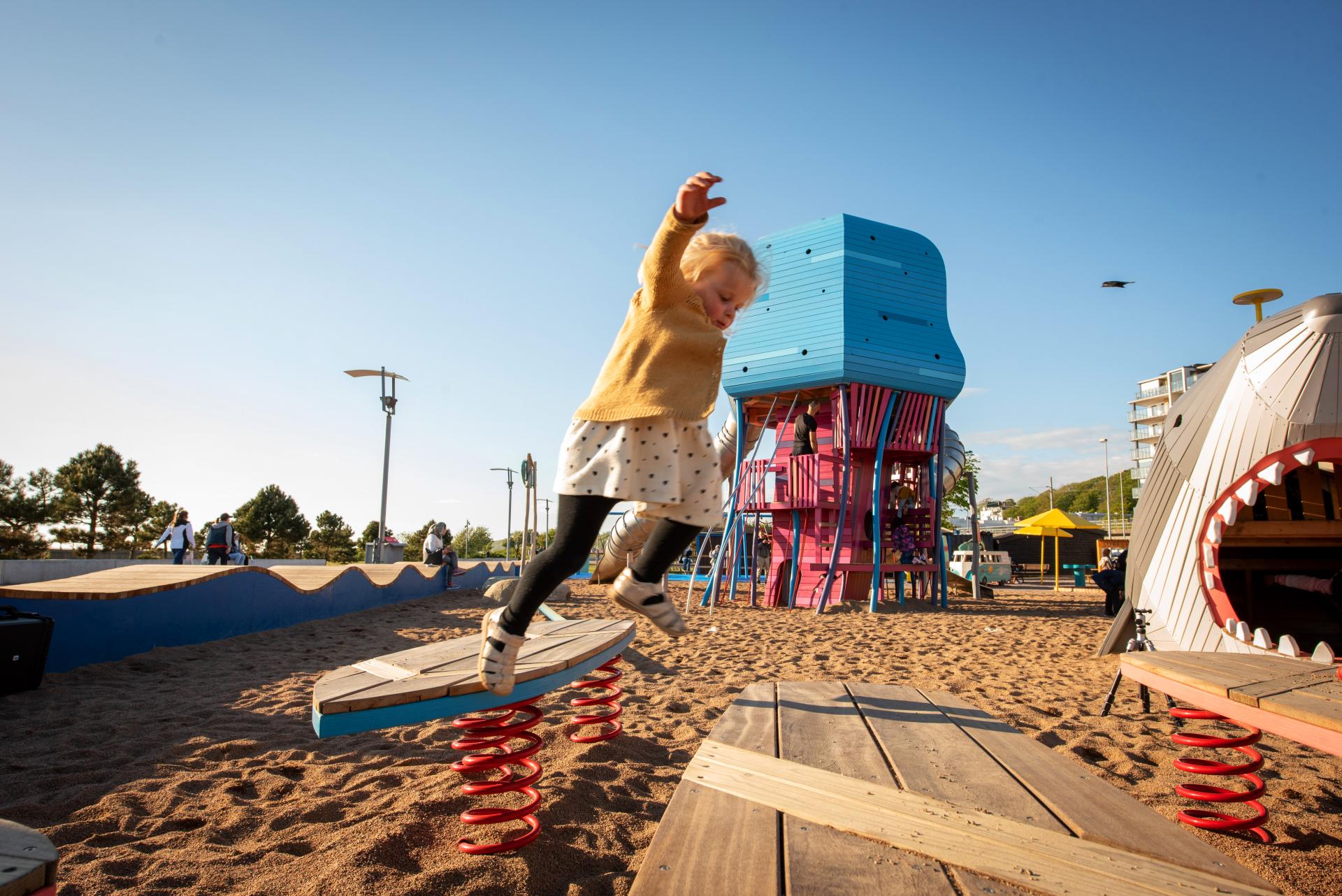 Girl jumping from fun surf boards at playground, MONSTRUM playgrounds