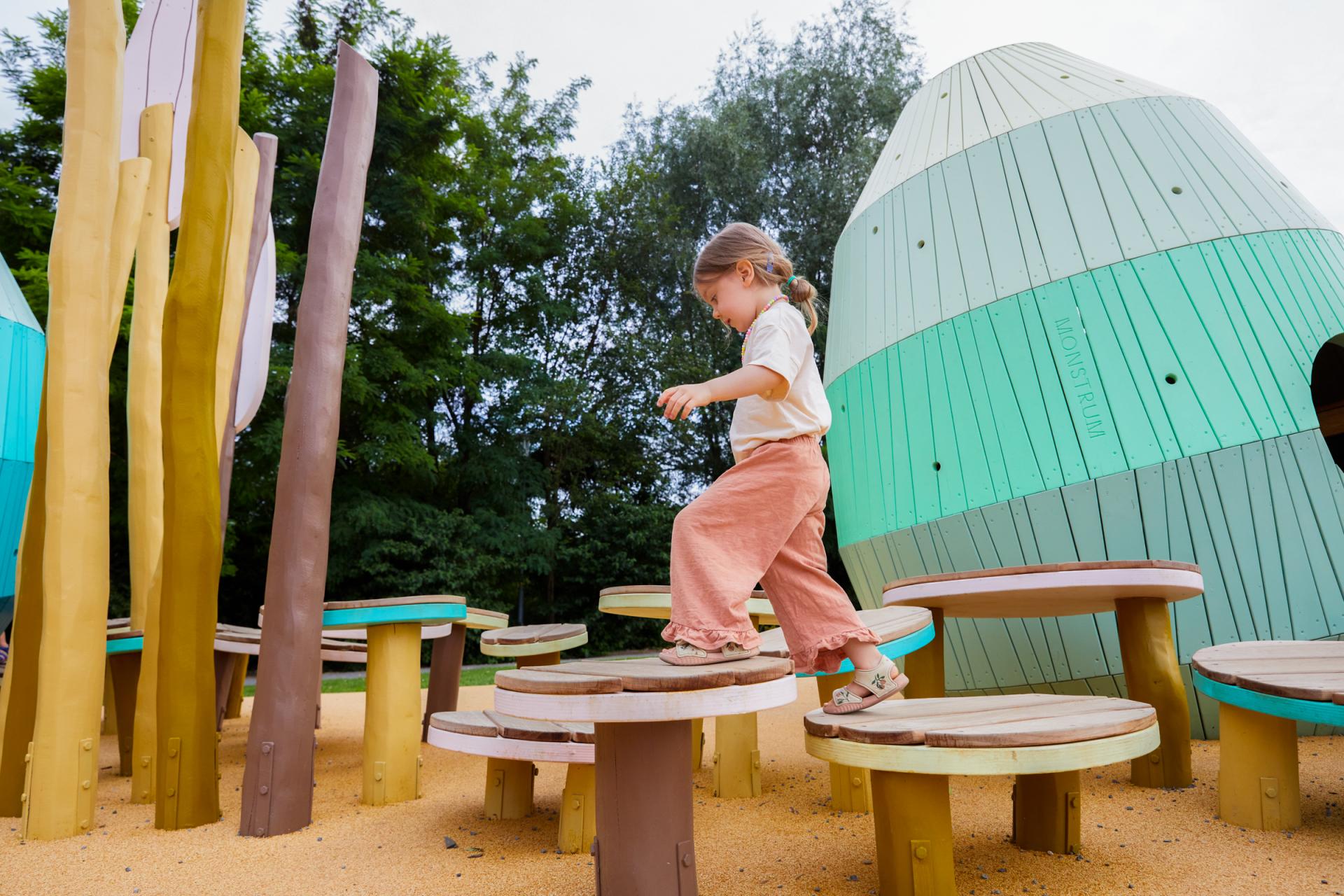 Girl jumping and running on obstacle course at MONSTRUM playground