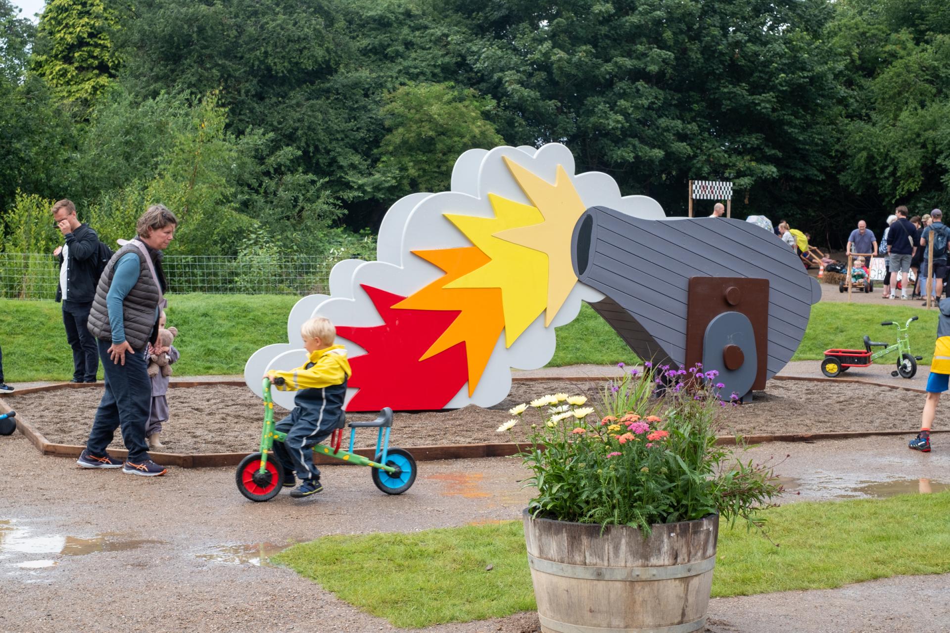 Kids playing by canon-shaped slide at playground