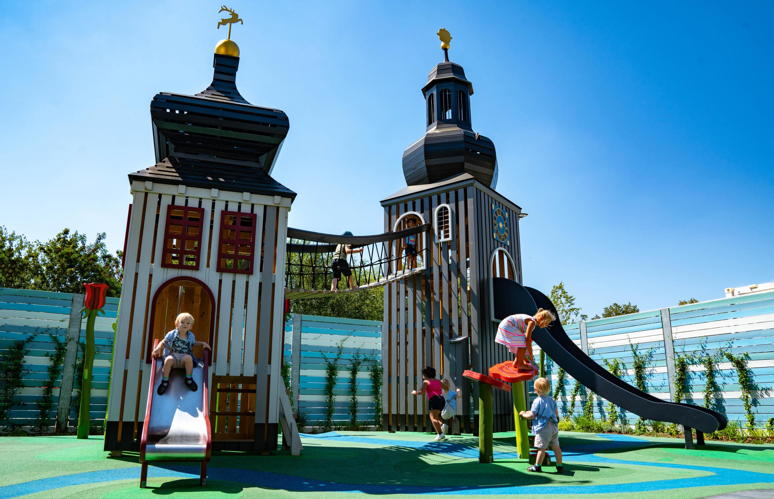 Wooden playground towers with kids playing there