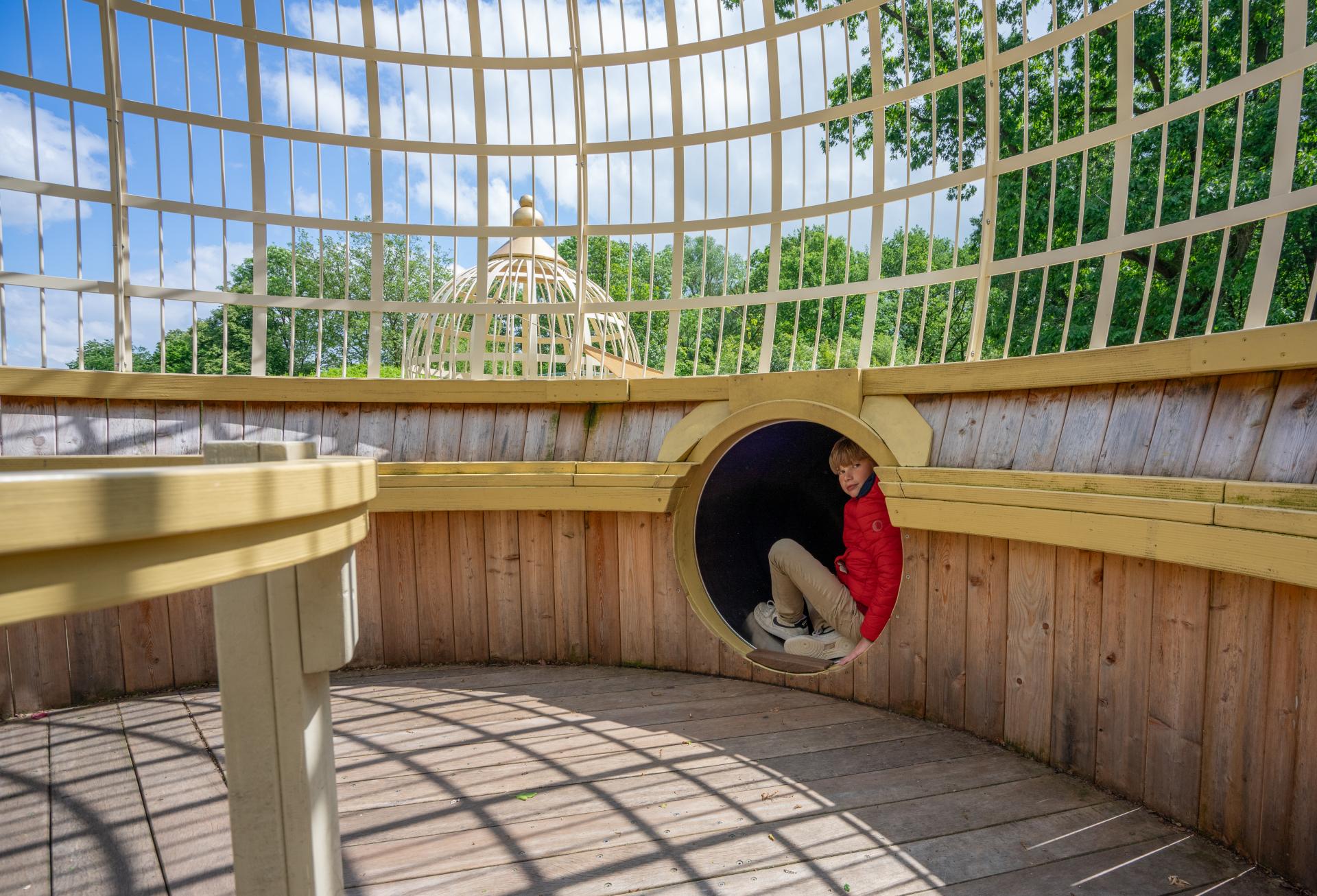 Boy sitting in dome of playground temple