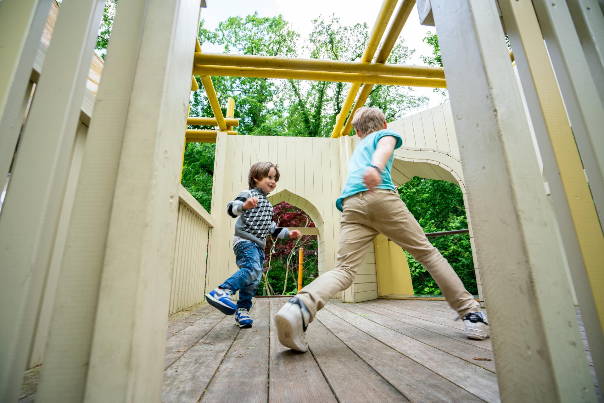 Boys playing and chasing each other at temple-themed playground