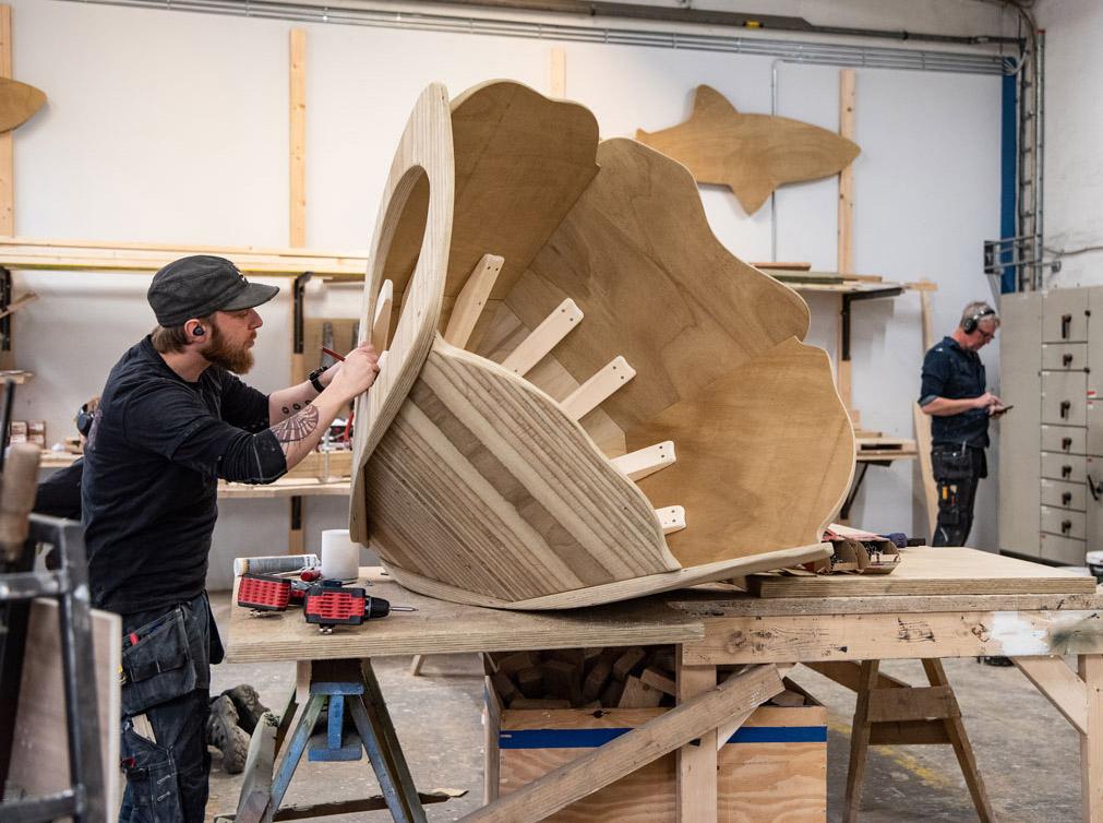 Carpenter working on wooden flower sculpture for playground