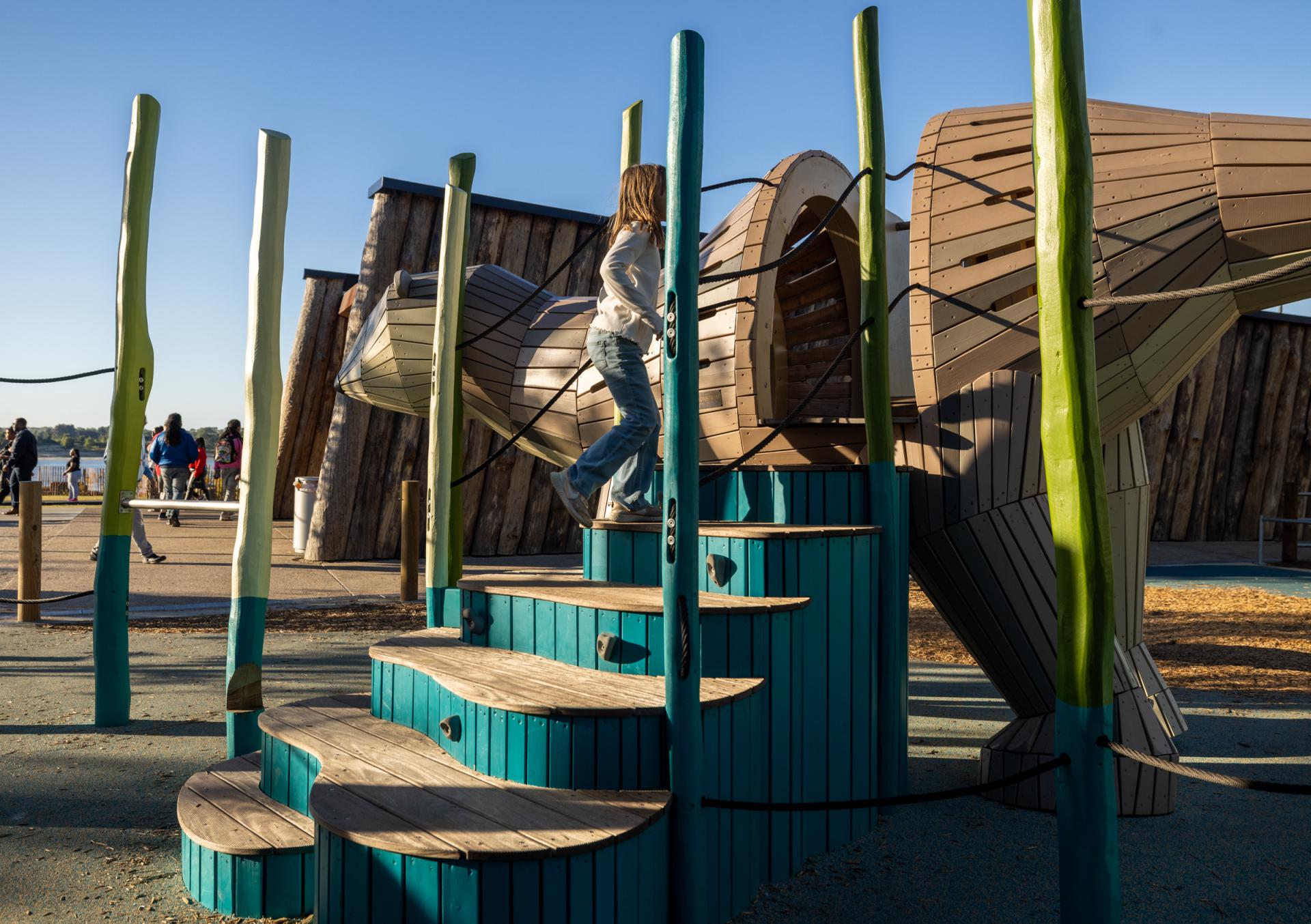 Girl going up stairs into baby otter playground structure