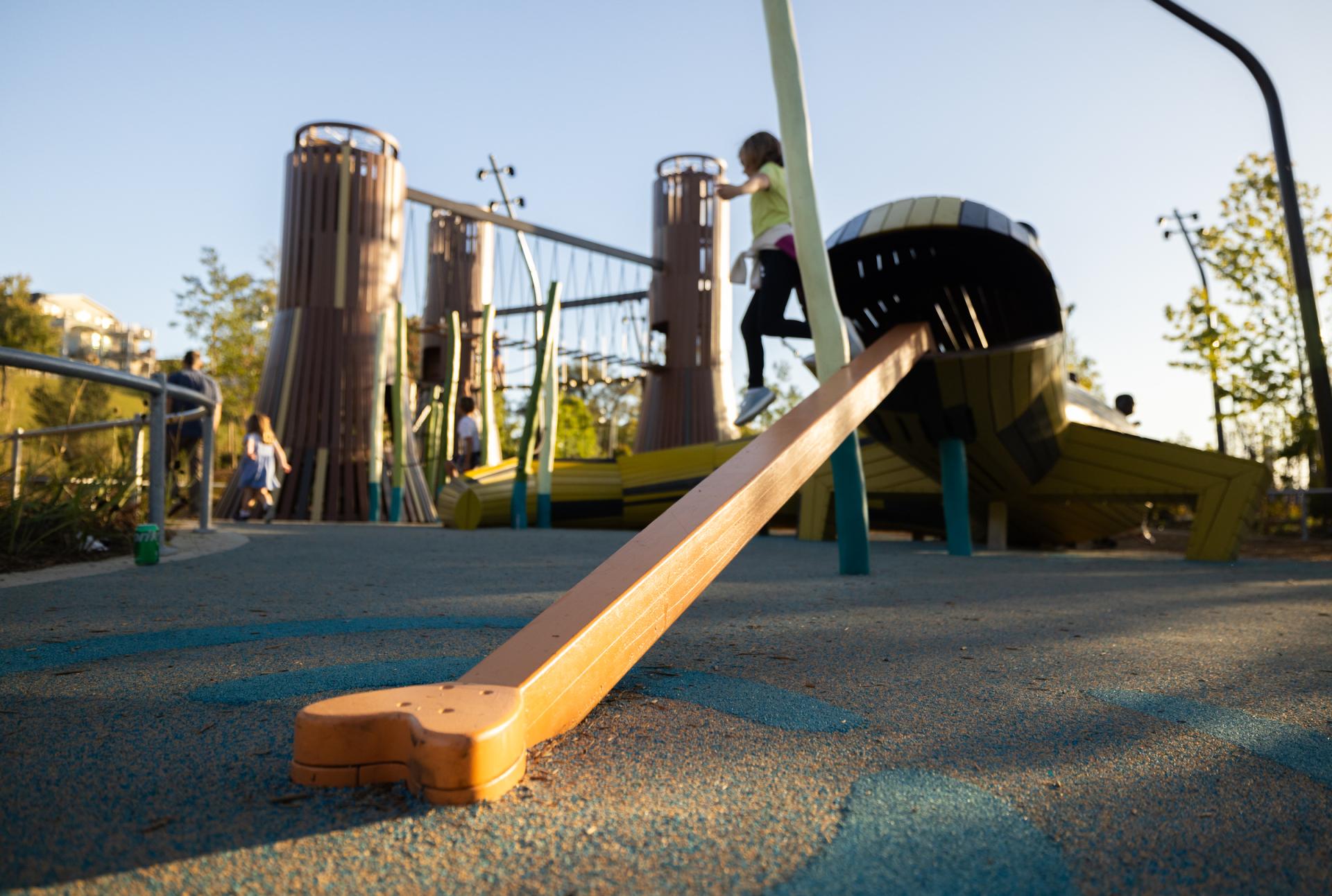 Girl jumping off the top of salamander playground structure