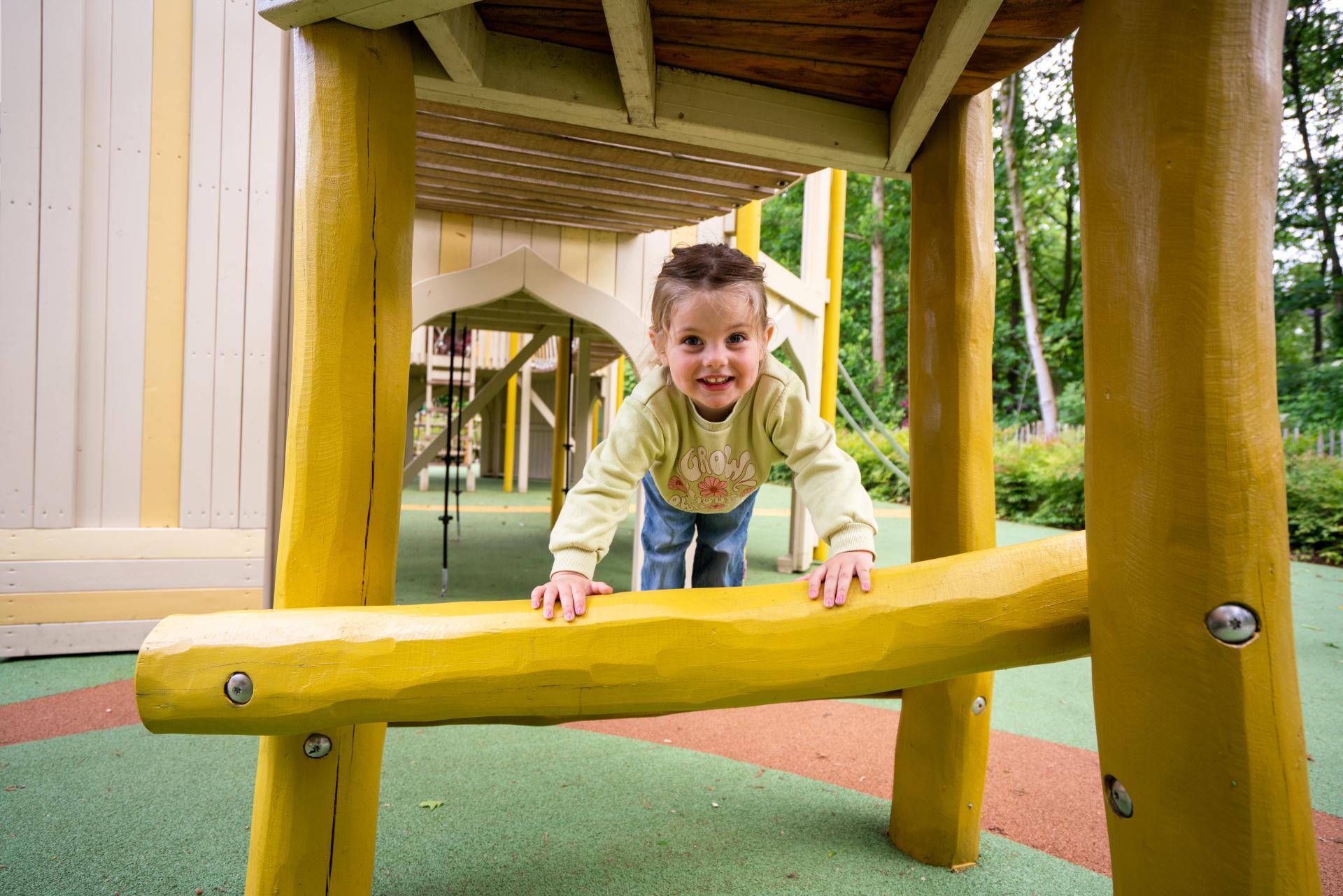 Girl smiling and playing at temple-themed playground