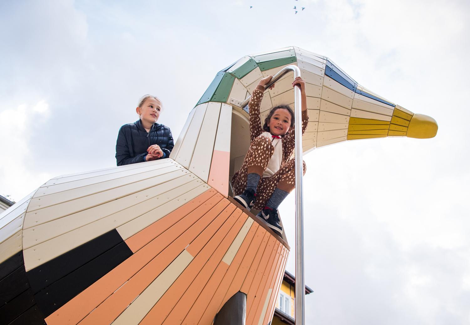 Girls climbing up high on playground duck