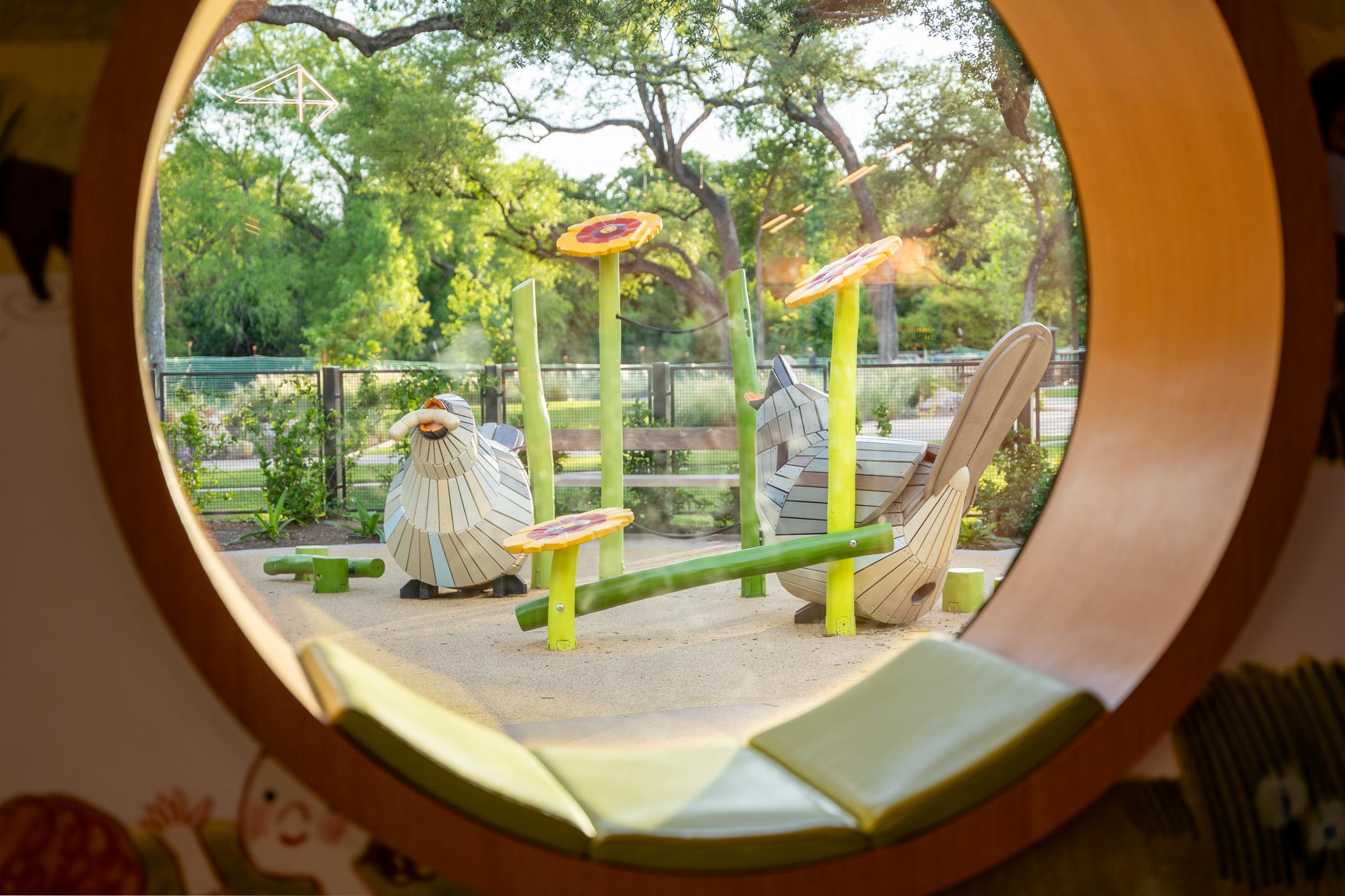 Baby bird playground structures seen from inside library through window