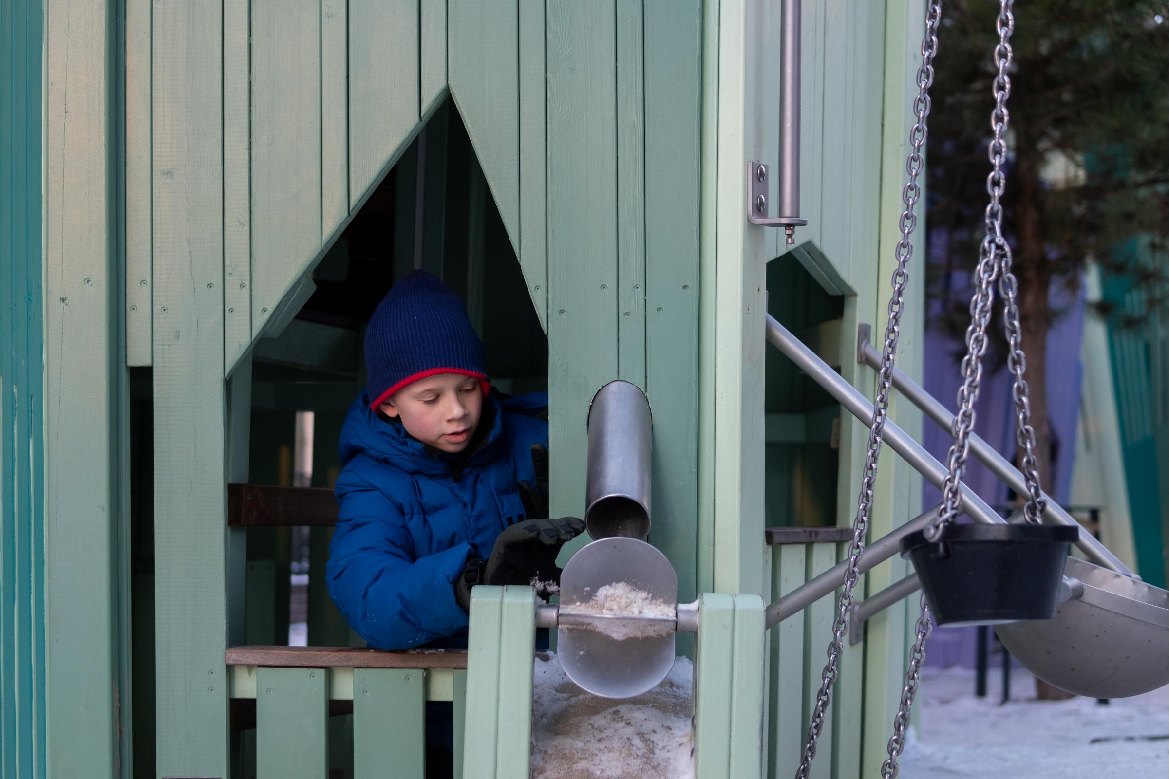 Boy playing in the snow at playground