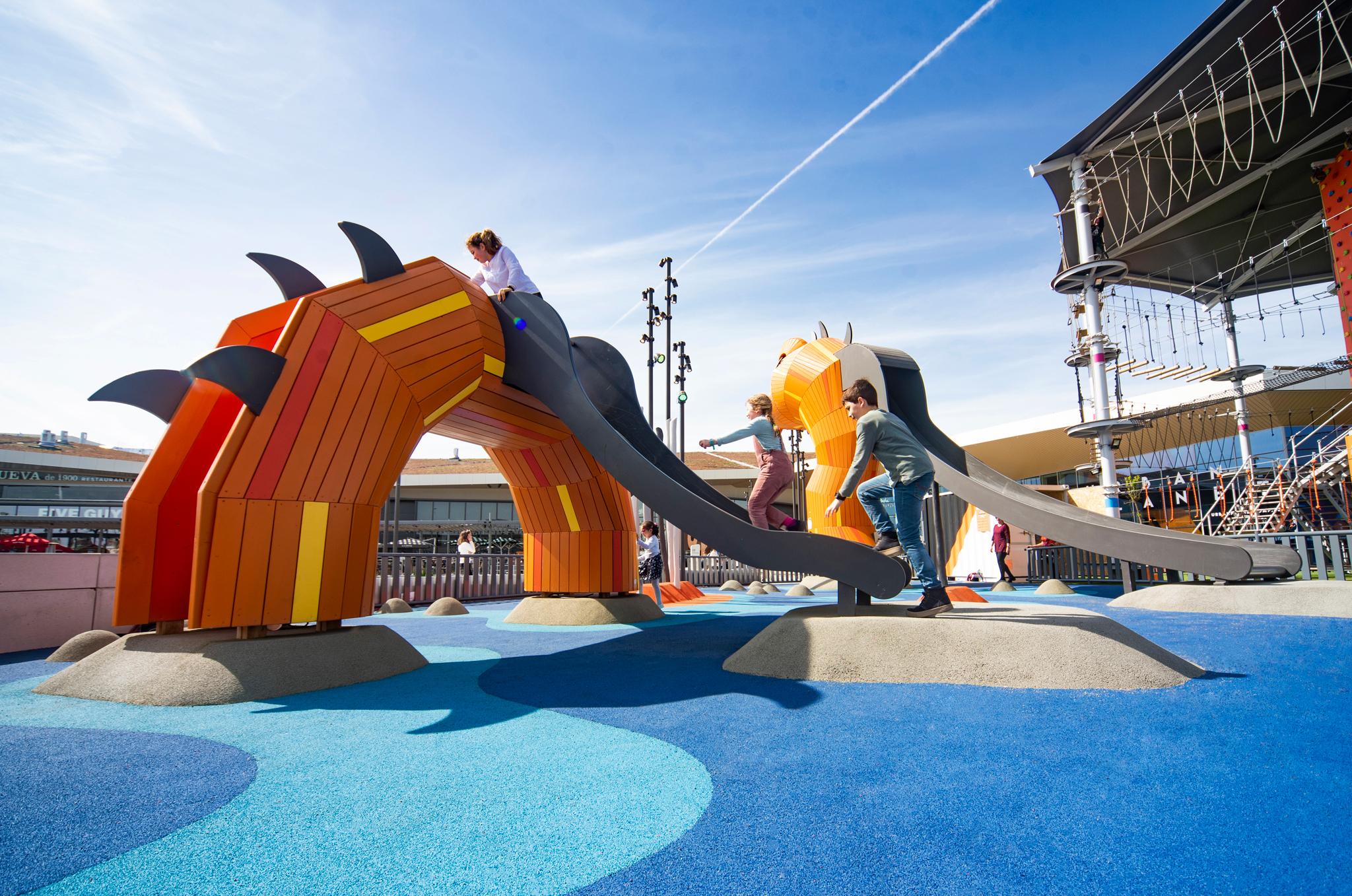 Children climbing up slide at sea dragon themed playground