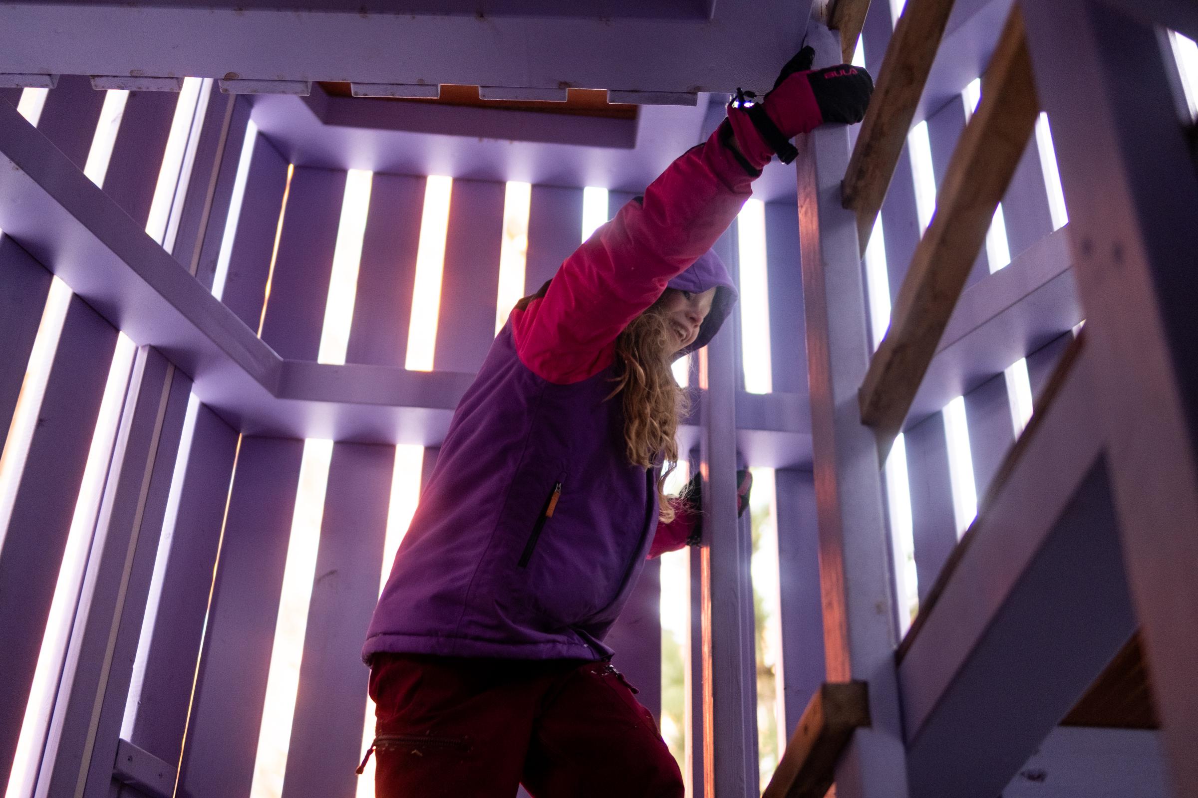 Girl climbing inside playground tower