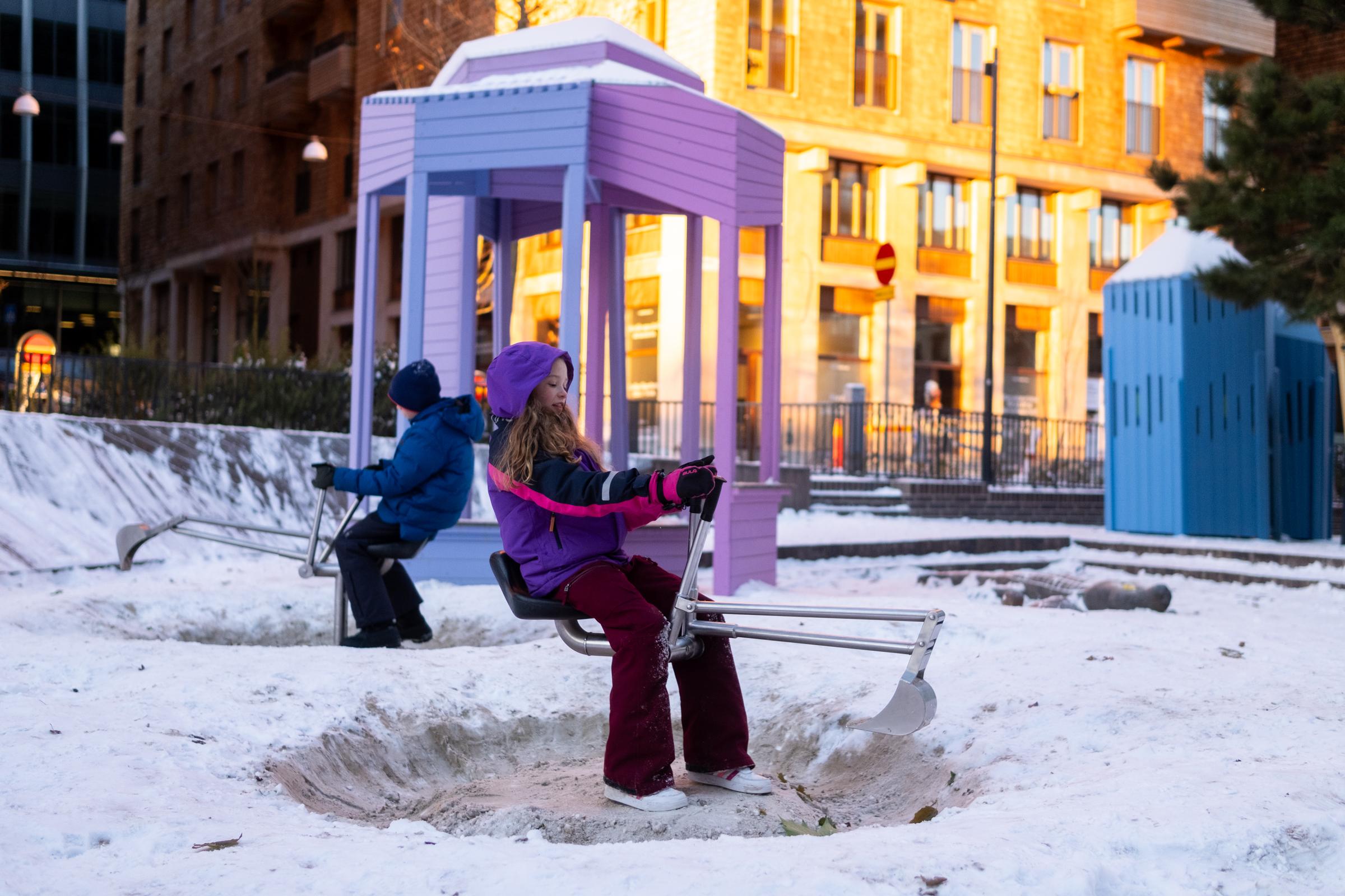 Kids playing together in snow at playground