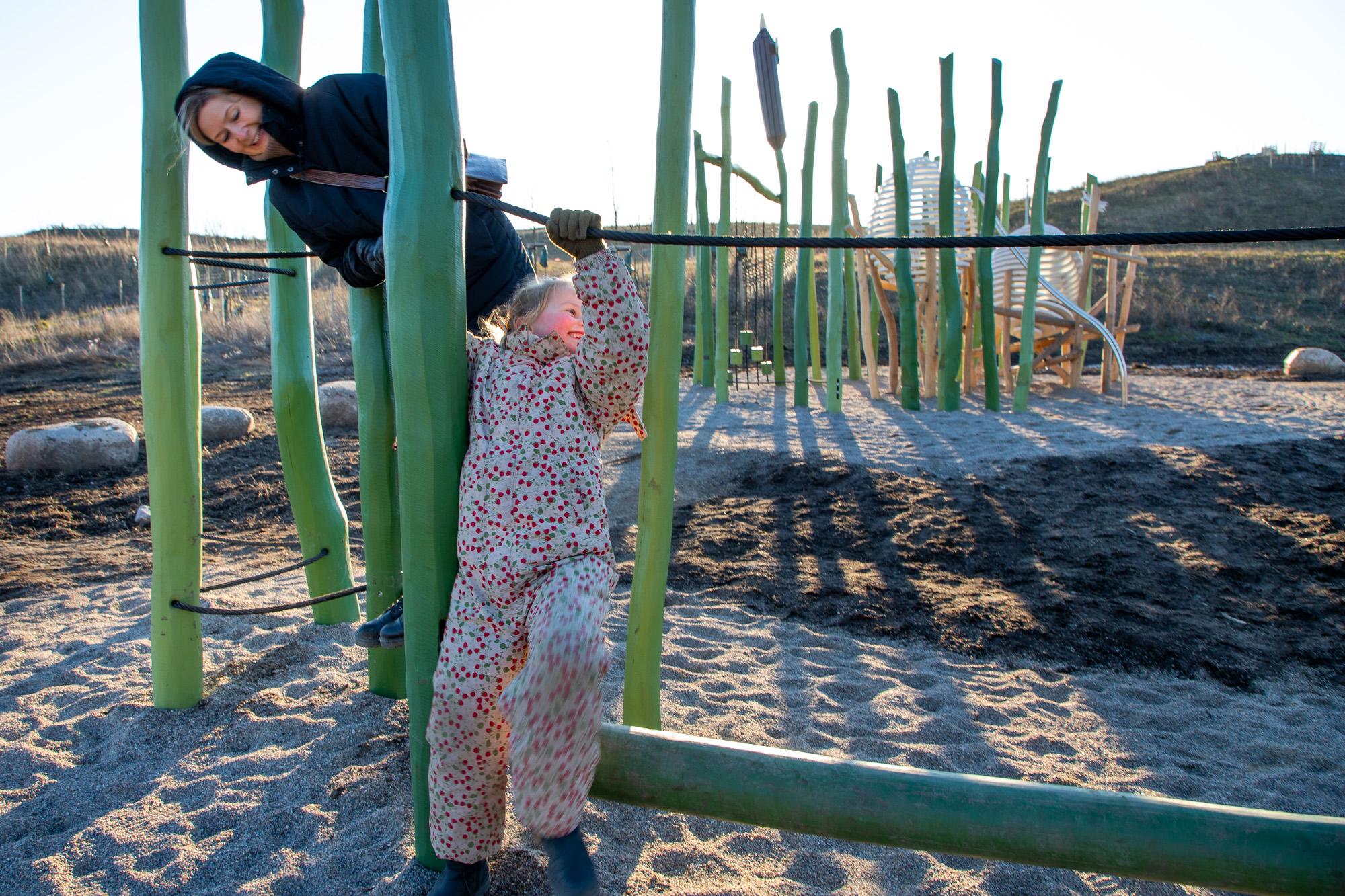 Girl and lady playing on playground laughing