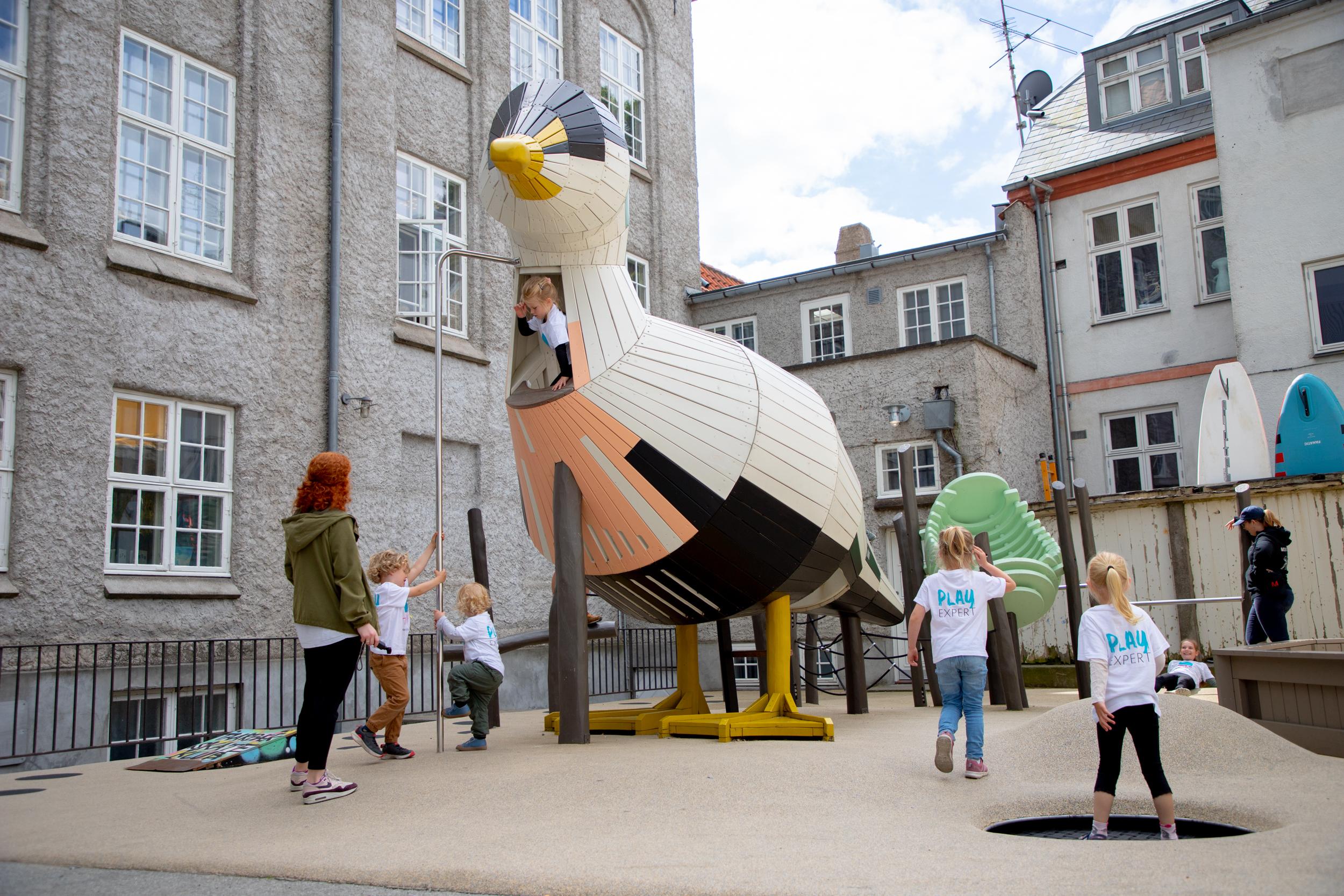 Children playing on big wooden playground duck at school playground