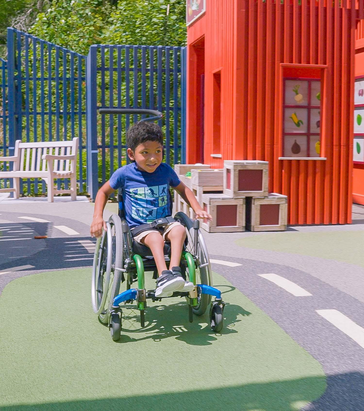 Boy in wheelchair wheeling around colourful playground