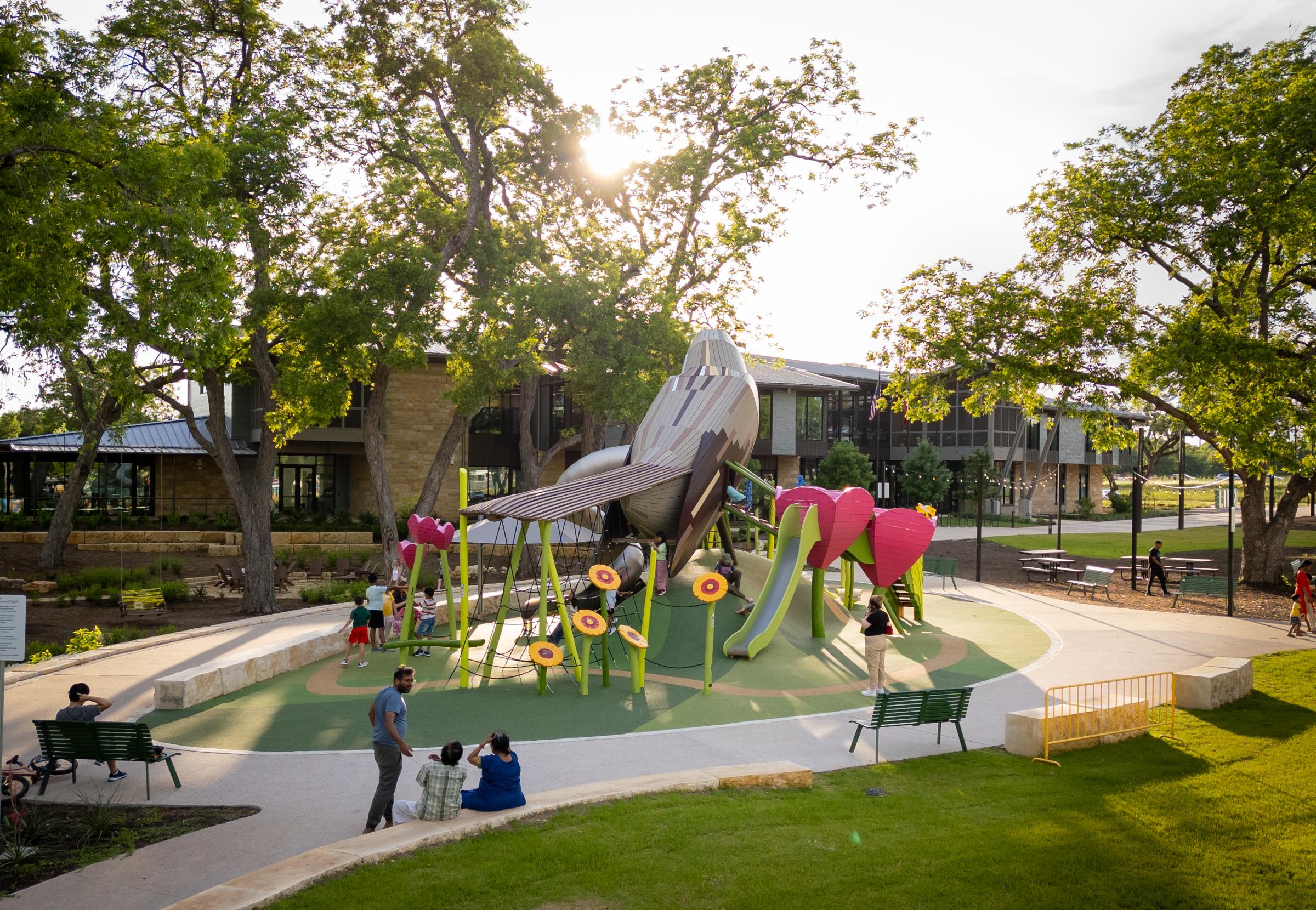 Kids playing at mockingbird playground structure in beautiful golden hour light