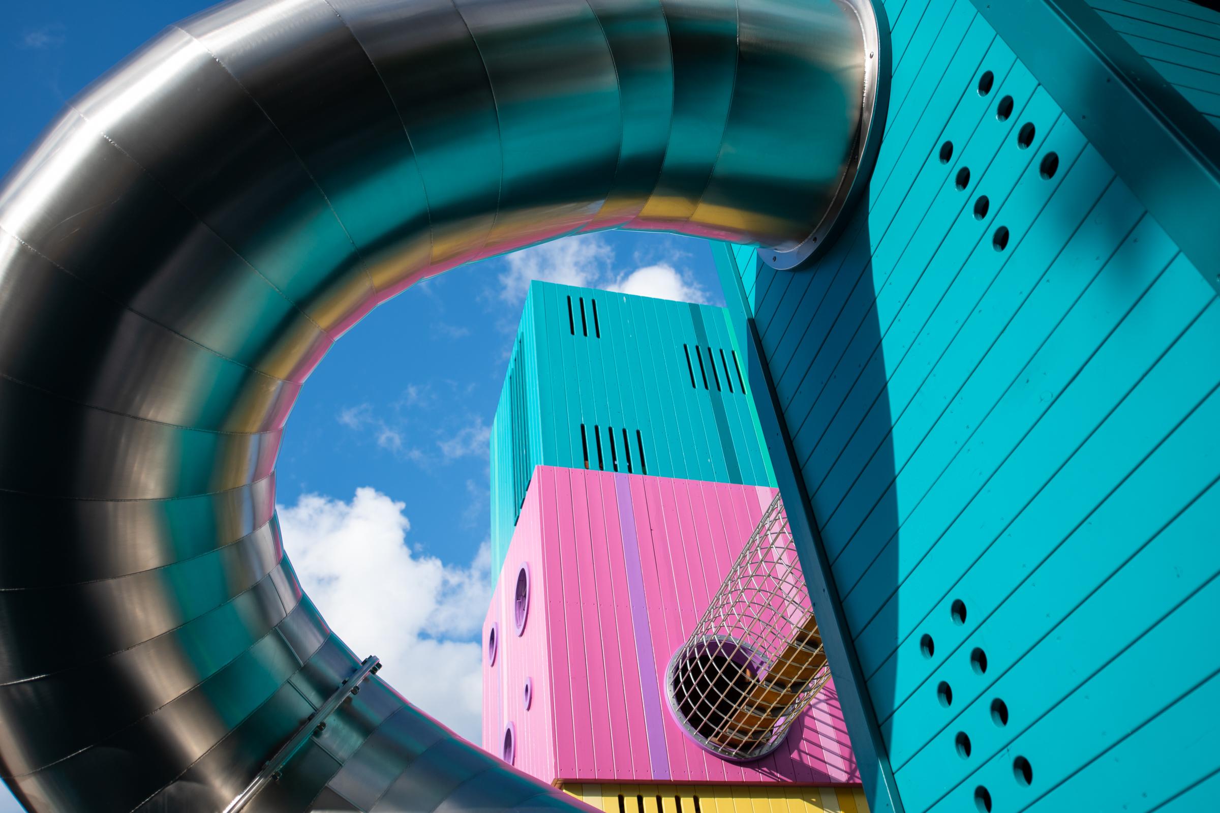Tube slide with reflections of colourful playground towers
