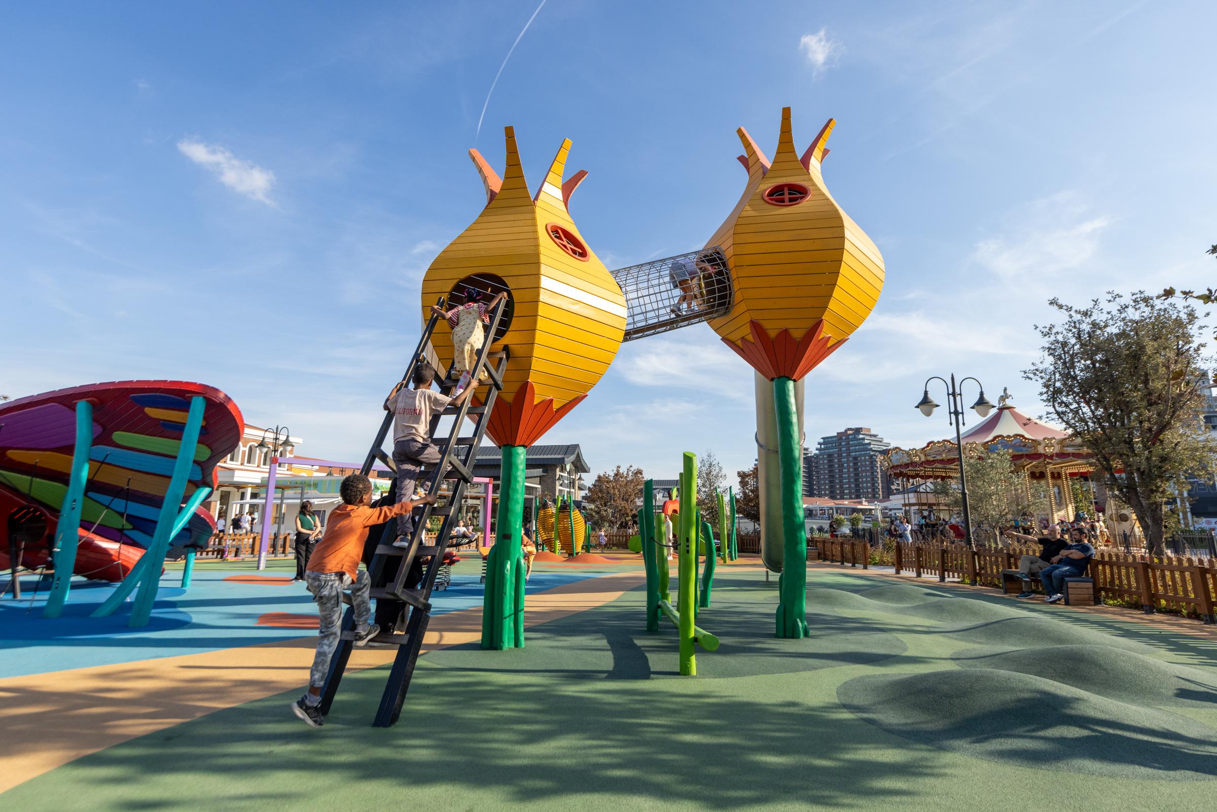 children climbing up into wooden flower towers at playground