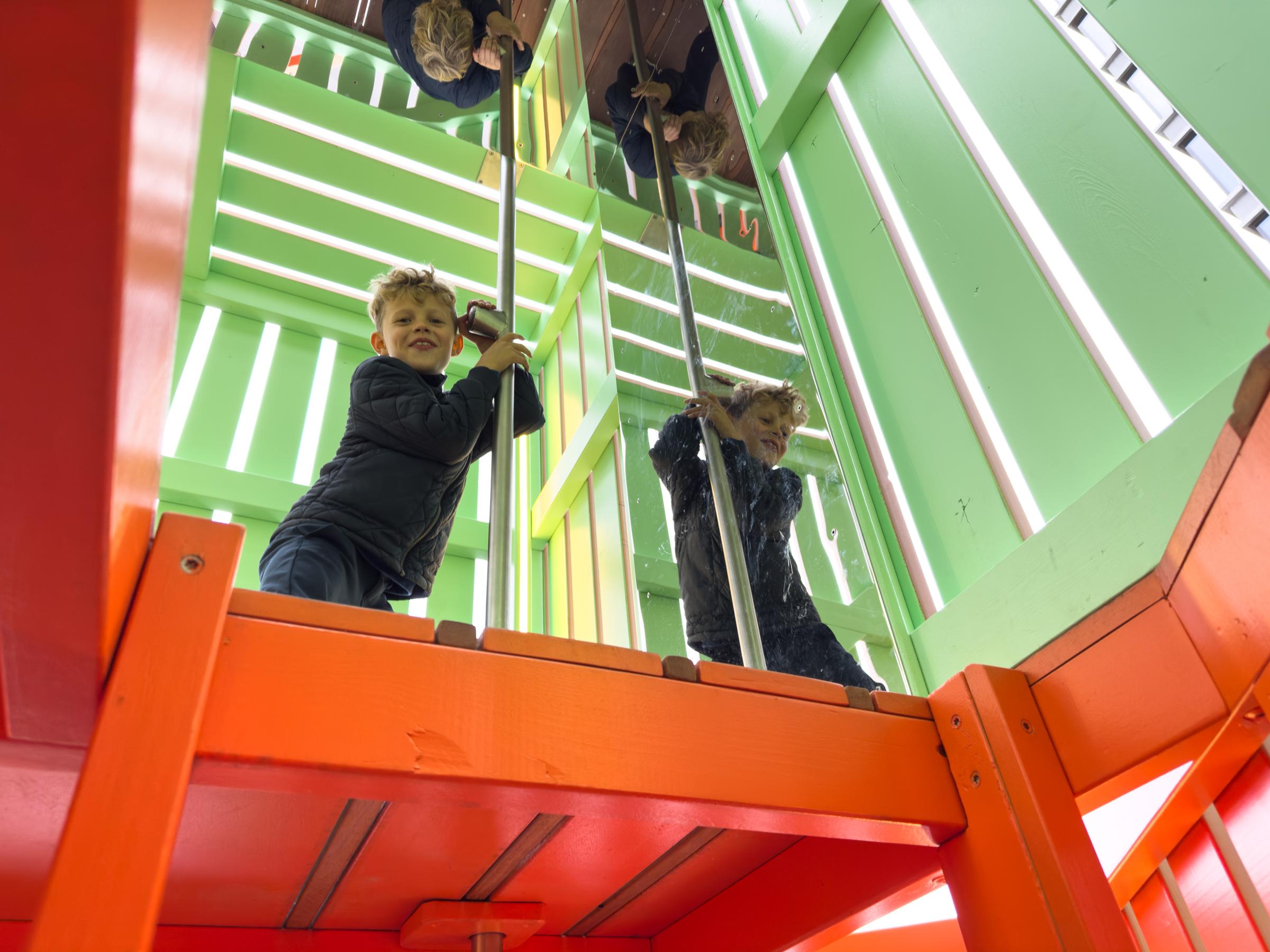 Boy using talking tube feature inside playground