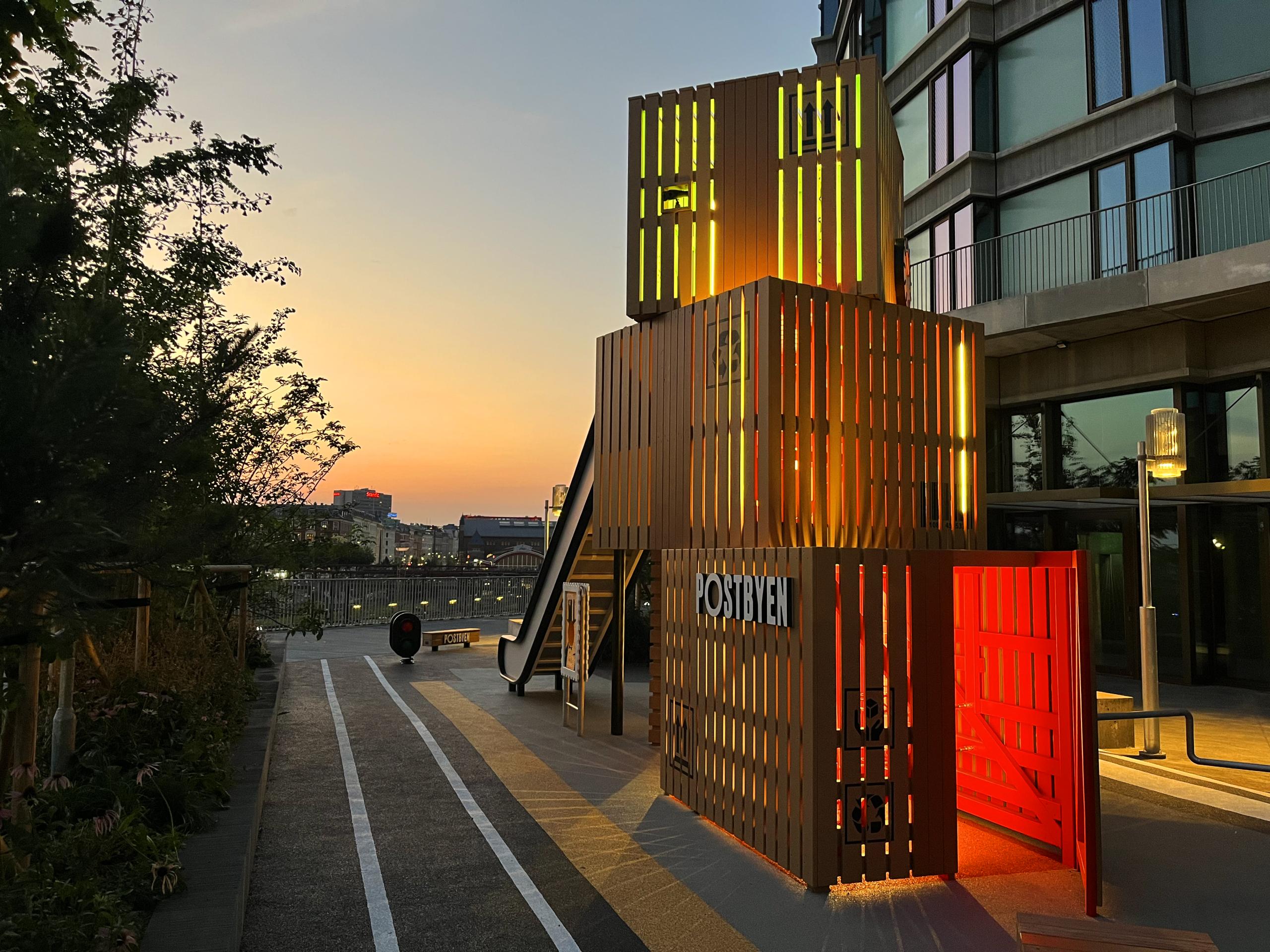 Post themed playground at night with lights on the inside