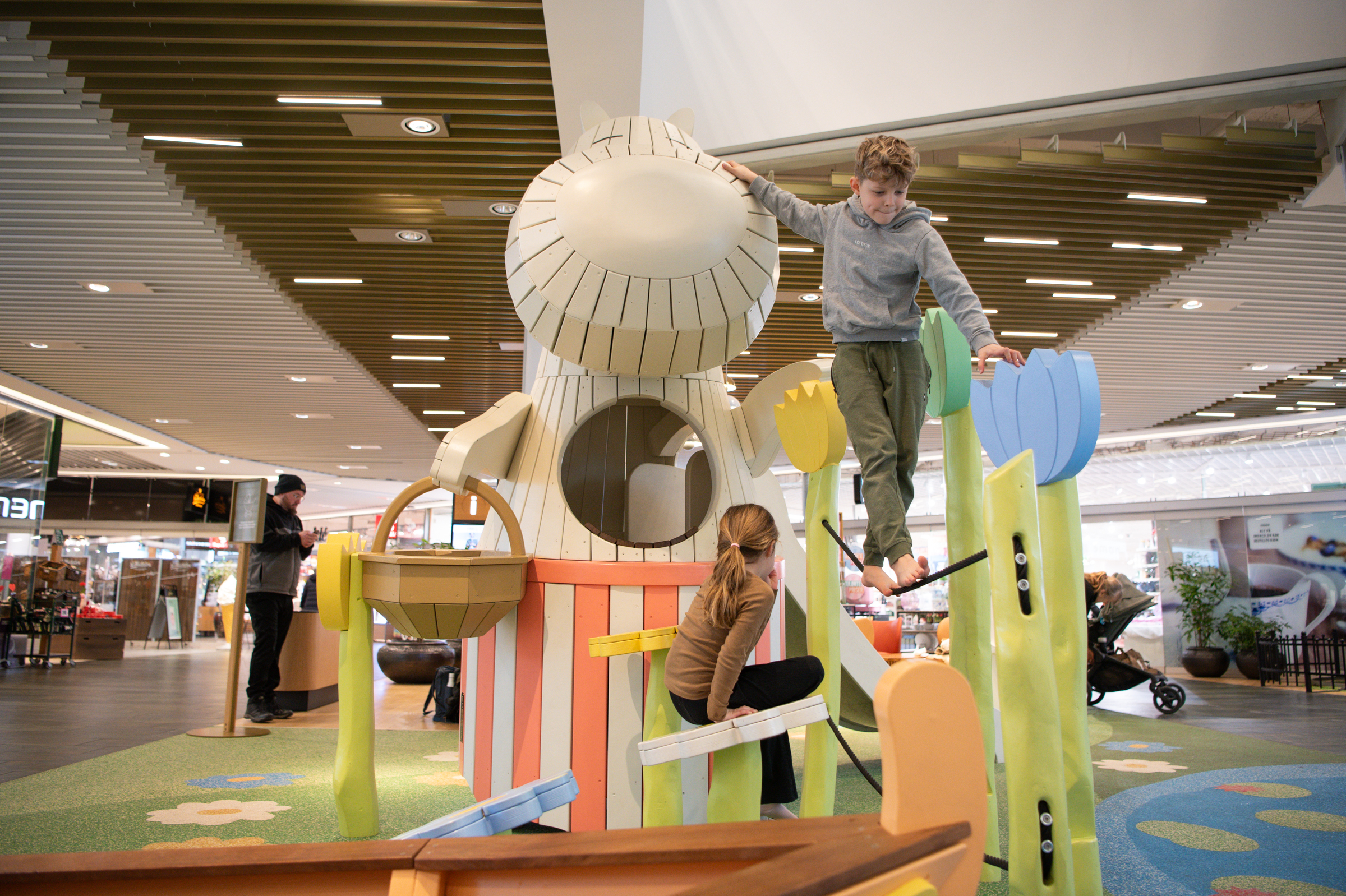 Boy and girl climbing on Moomin playground structure