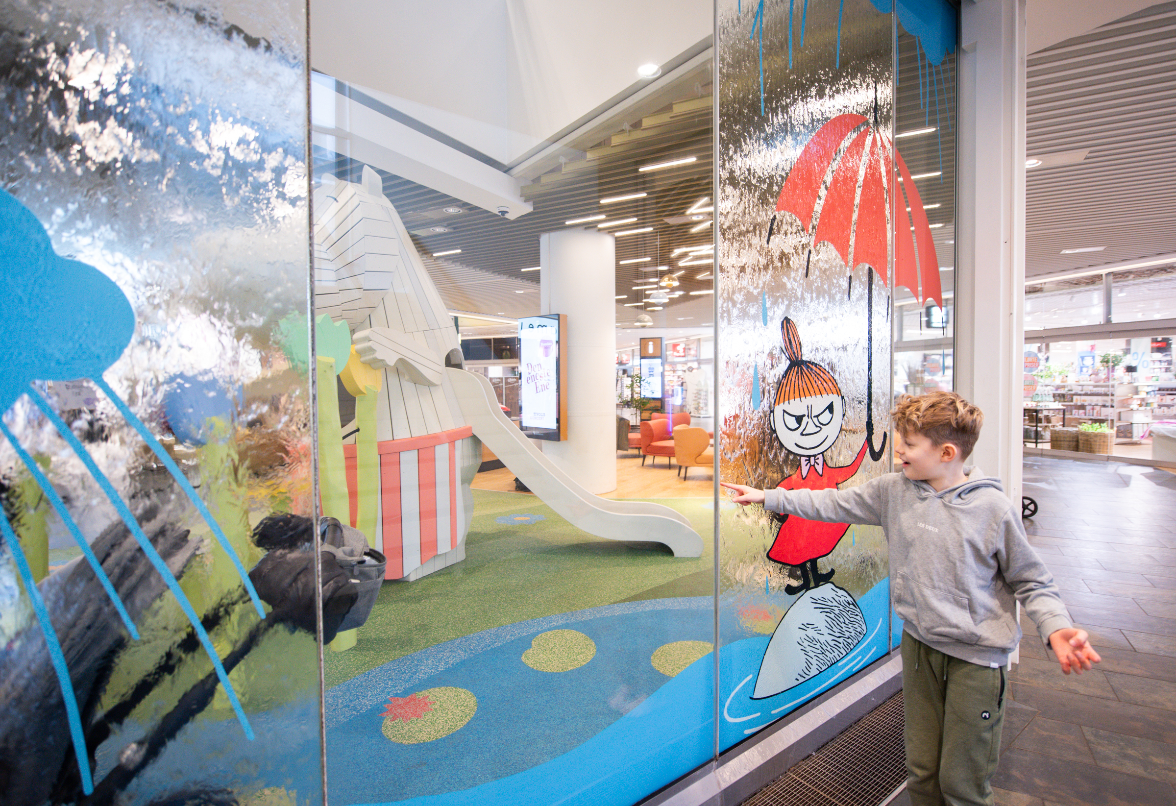 Boy running his finger through water feature wall
