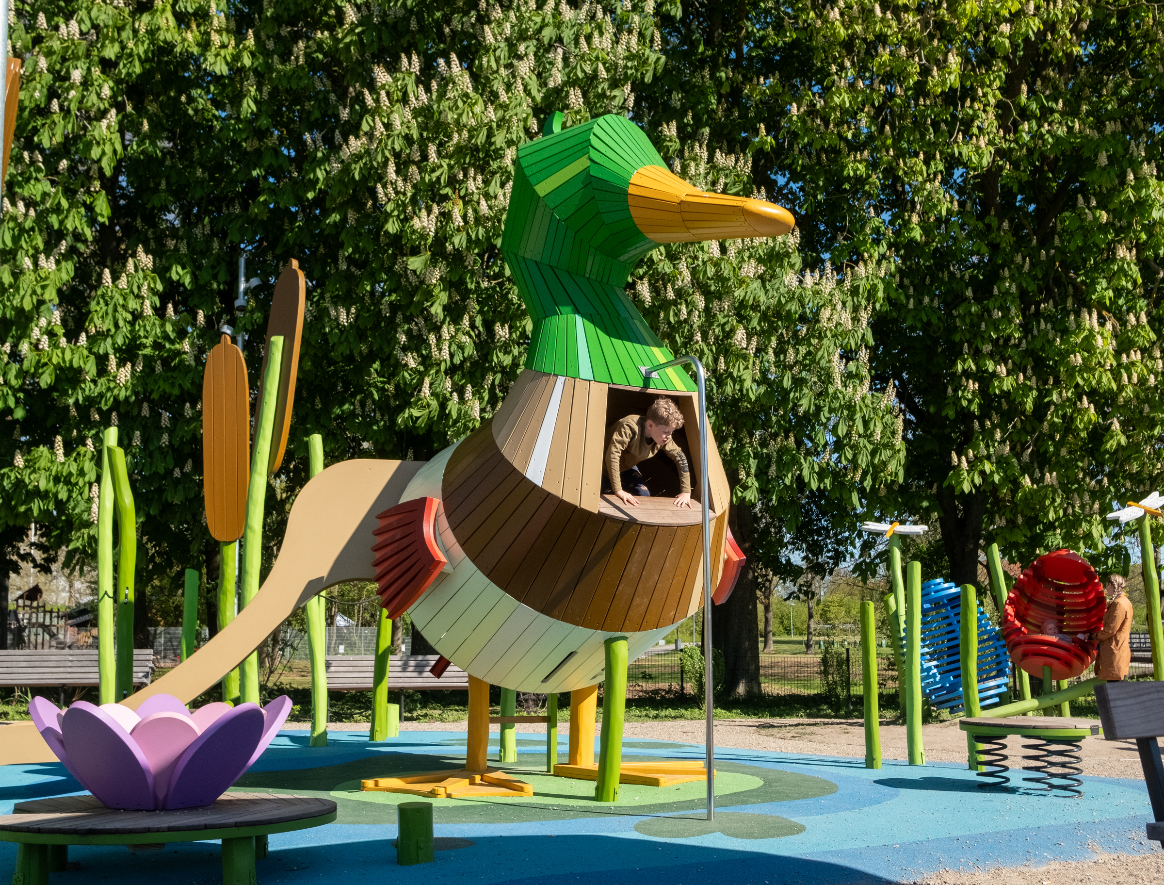 Boy climbing on duck-fish playground structure 