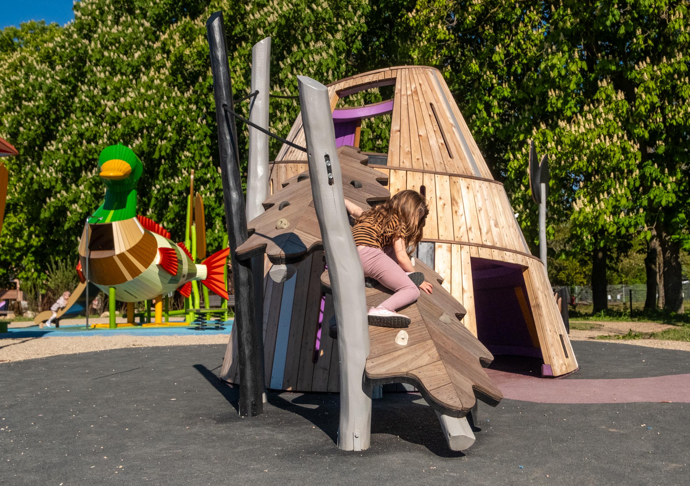 Girl climbing up playground mountain