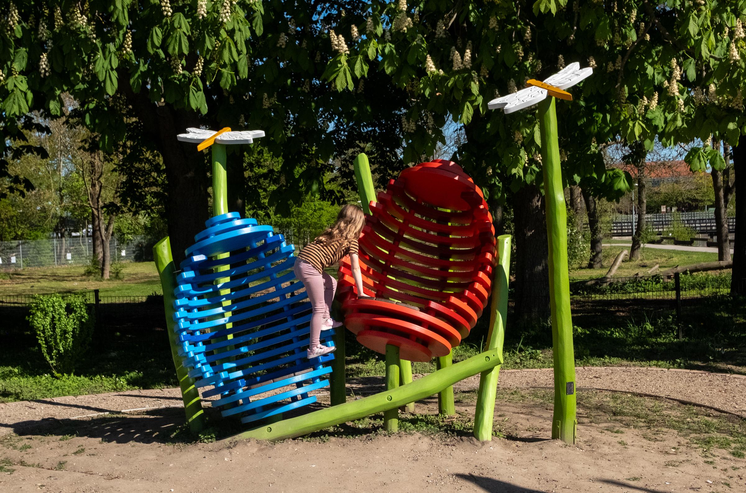 Girl climbing in wooden eggs at playground