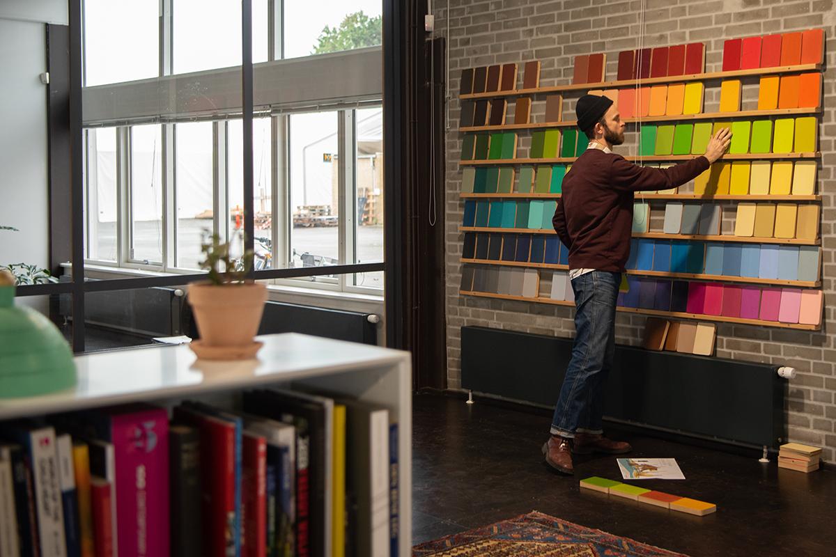 MONSTRUM Playground designer choosing colours from large colour sample wall at studio