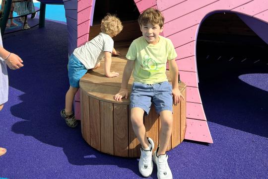 Boy sitting on transfer platform at playground