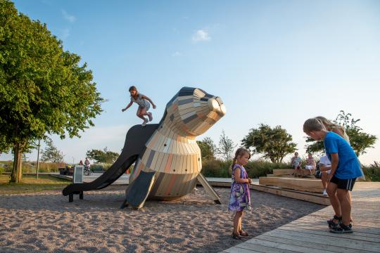 Girl jumping off seal playground feature