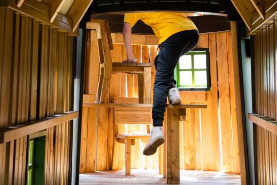 Kid climbing up inside playground structure