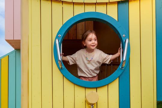 Girl peeking out of playground feature