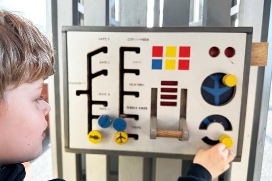 Kid playing with sensory board at airport playground