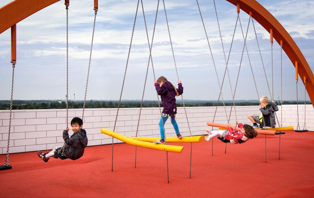 Children playing on swings at LEGO House