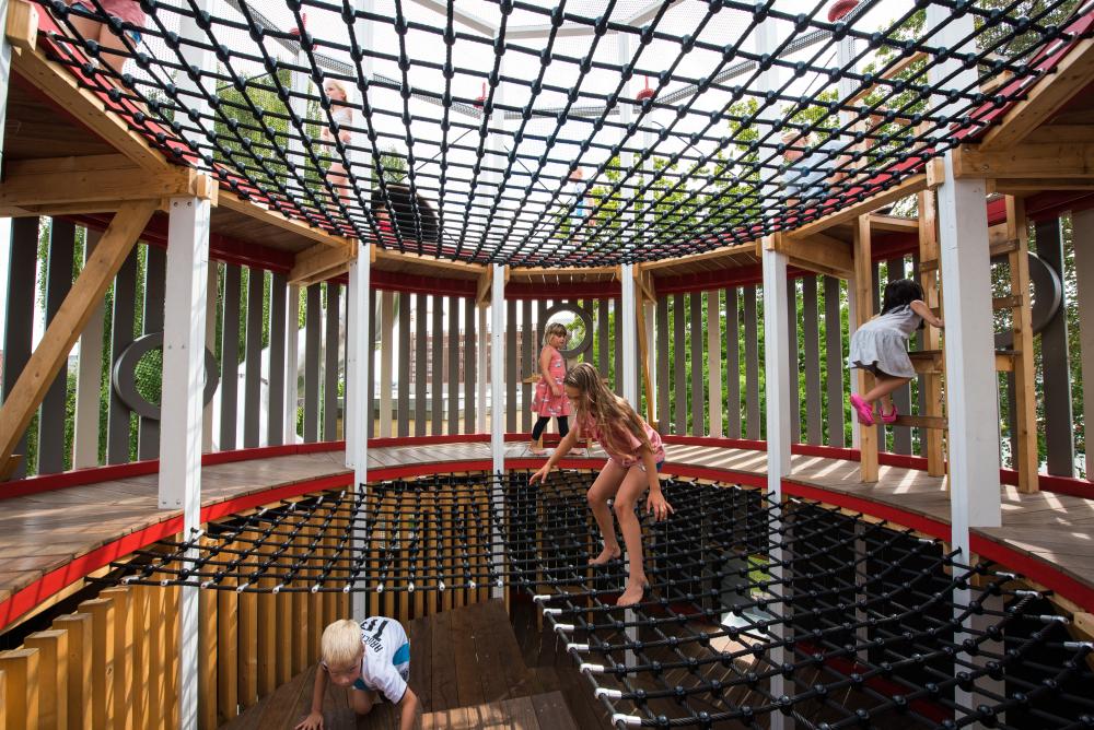 Girl playing on climbing net, MONSTRUM playgrounds