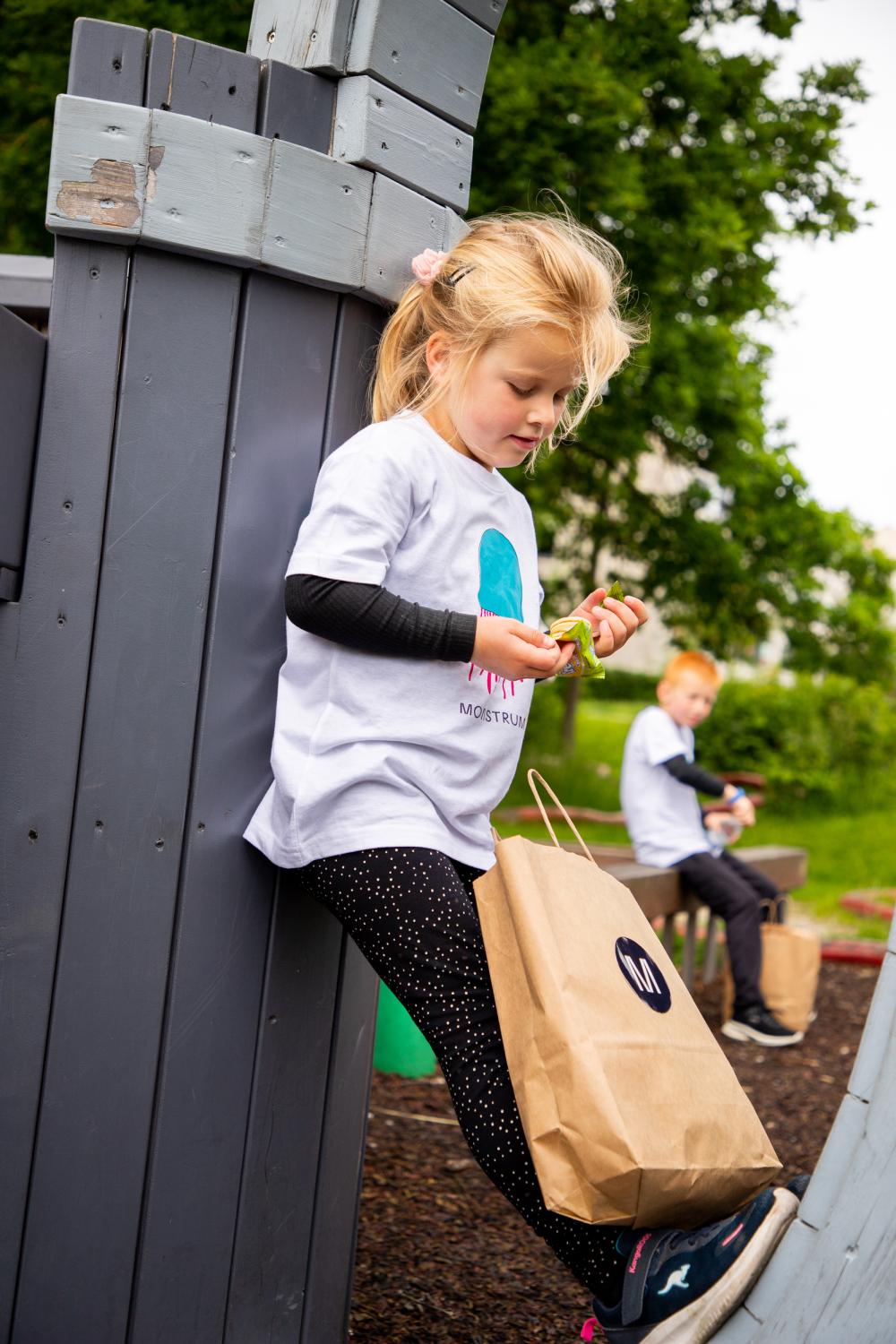 Girl eating a snack bag at playground