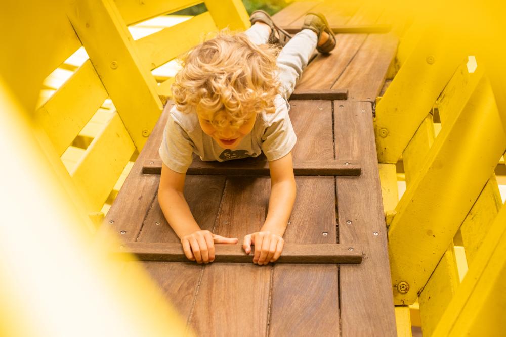 Boy playing inside snake playground structure
