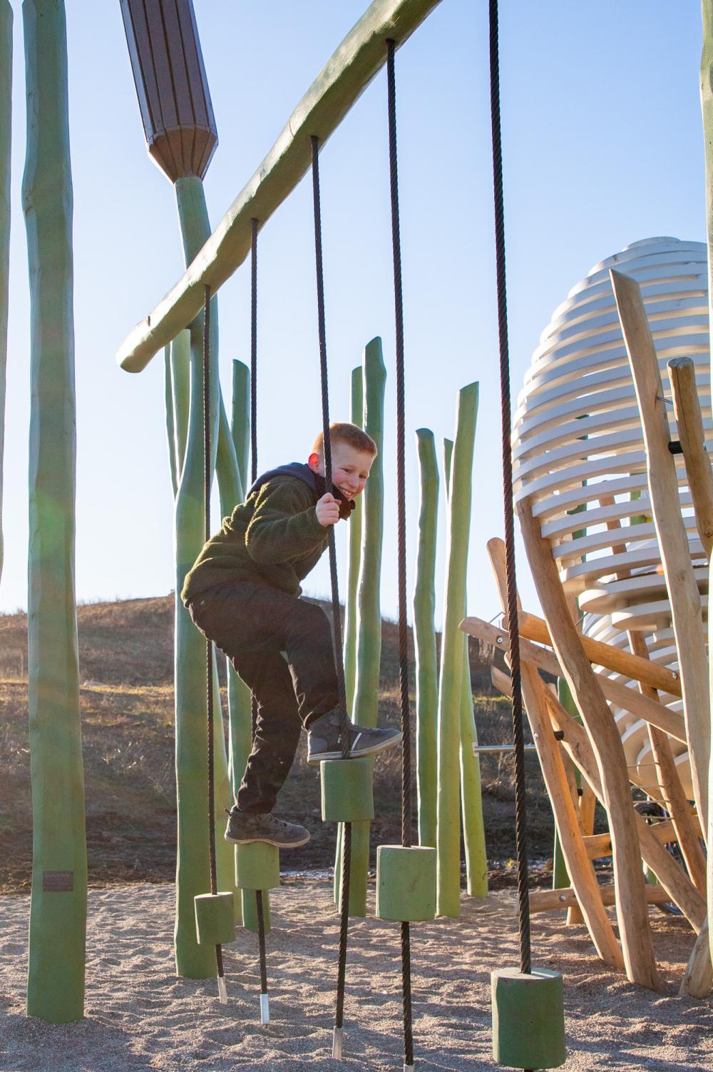 Boy climbing on balancing blocks at playground