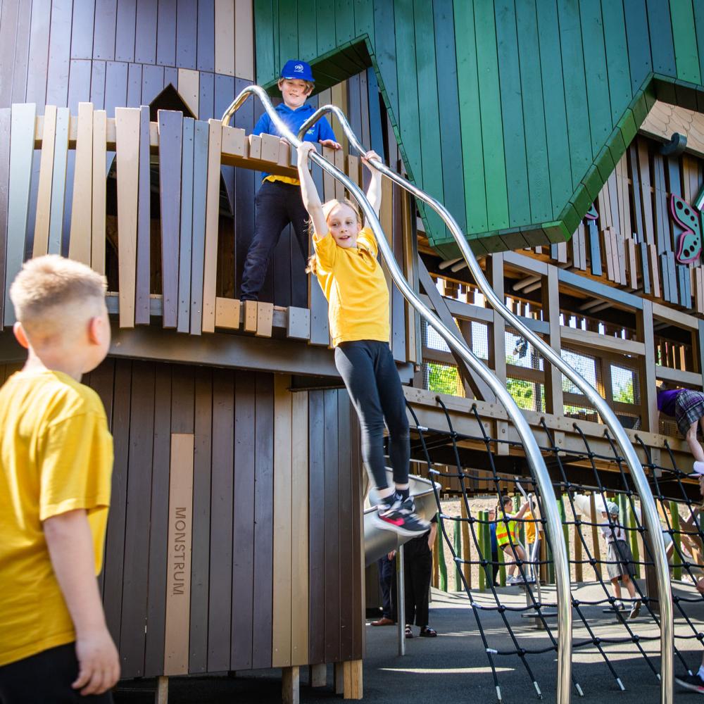 Girl sliding down steel bars at playground